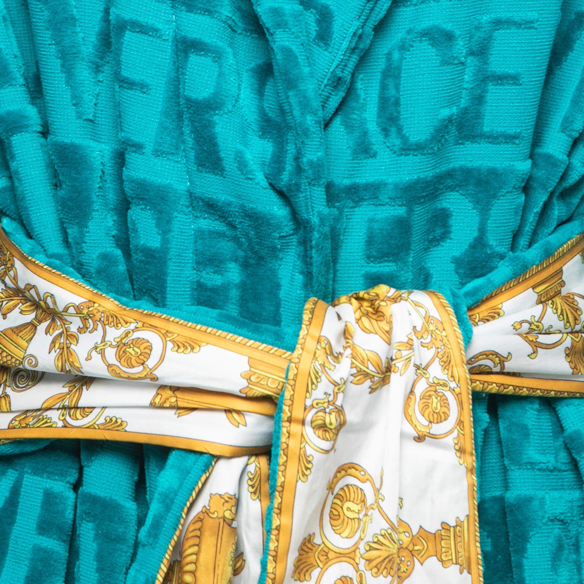 The Versace Home bathrobe exudes luxury and style. Crafted from plush terry fabric in a vibrant green hue, it features the iconic Versace logo pattern. With a belted waist, this robe offers comfort and sophistication for a lavish home spa