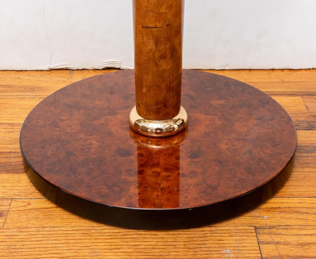 Table d'appoint Versace Home, avec un plateau circulaire en verre au-dessus d'un support colonne effilé en laque fantaisie de bois de bourgogne sur un socle doré au-dessus d'une base circulaire, également finie. 24,5