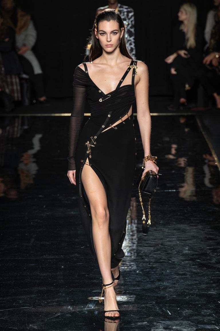 Offered brand new Versace's current version of the safety pin dress.   Fashioned of a substantial black silk crepe strategically adorned with Versace signature safety pins.  Dress is fully lined and features the Versace iconic body suit to adjust
