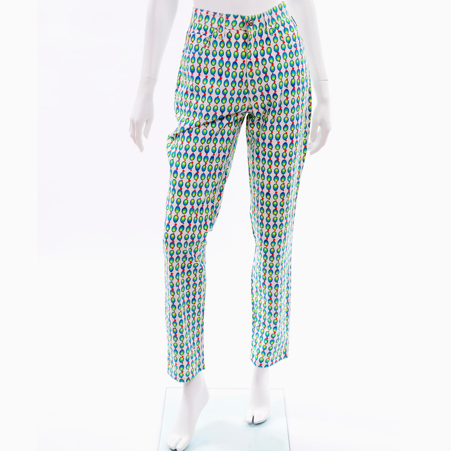 These are fabulous vintage jeans from the 1990s by Gianni Versace Jeans Couture. These peg legged  jeans are white with blue, green, red and yellow stylized circles that resemble abstract olives! High Waisted pants with the Versace monogram logo