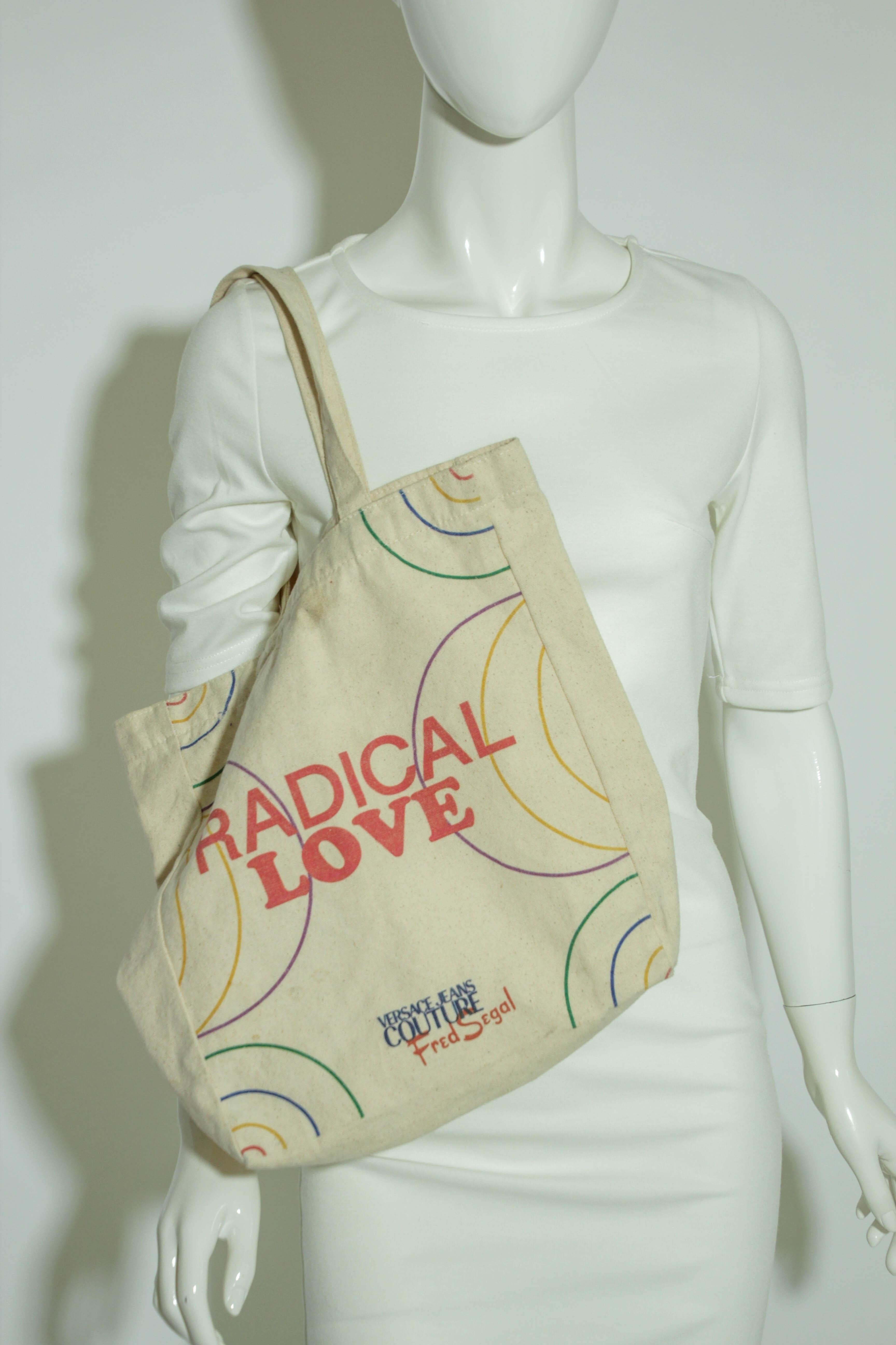 Radical Love Versace Jeans Couture Canvas Tote Bag for Fred Segal Los Angeles.
Design printed on one side only.
Dimensions: 14 in. x 13 in not including straps.
23 in. including straps.
Radical Love Versace Jeans Couture Canvas Tote Bag. 
Good