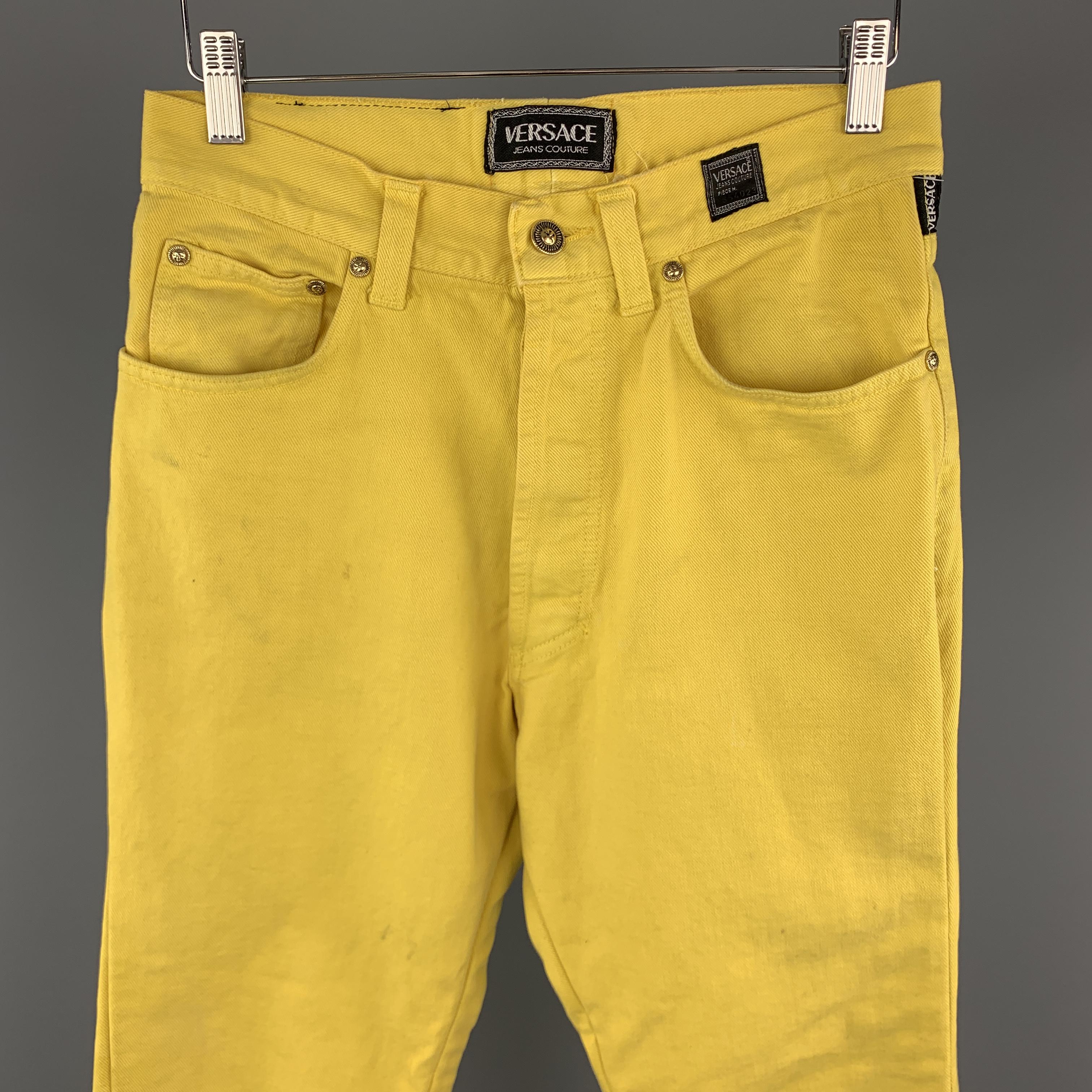Vintage VERSACE JEANS COUTURE jeans come in yellow denim with a slim straight leg fit and gold tone sun face hardware. Wear throughout. As-is. Made in Italy.

Good Pre-Owned Condition.
Marked: 34 48

Measurements:

Waist: 30 in.
Rise: 12 in.