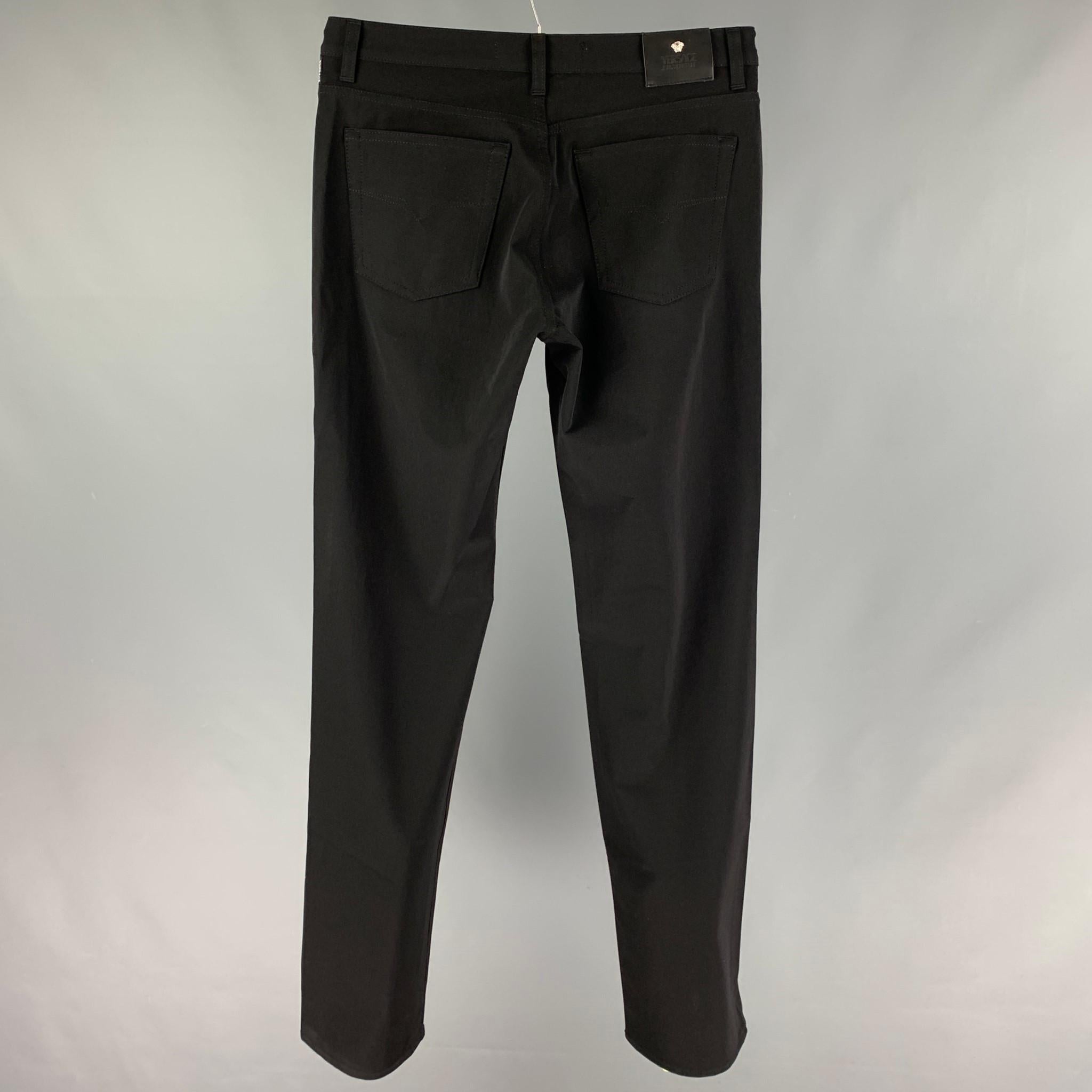 VERSACE JEANS COUTURE pants comes in a black nylon featuring silver tone hardware medusa buttons, flat front, and a zip fly closure. 

Very Good Pre-Owned Condition.
Marked: 34/48

Measurements:

Waist: 32 in.
Rise: 11 in.
Inseam: 36 in. 