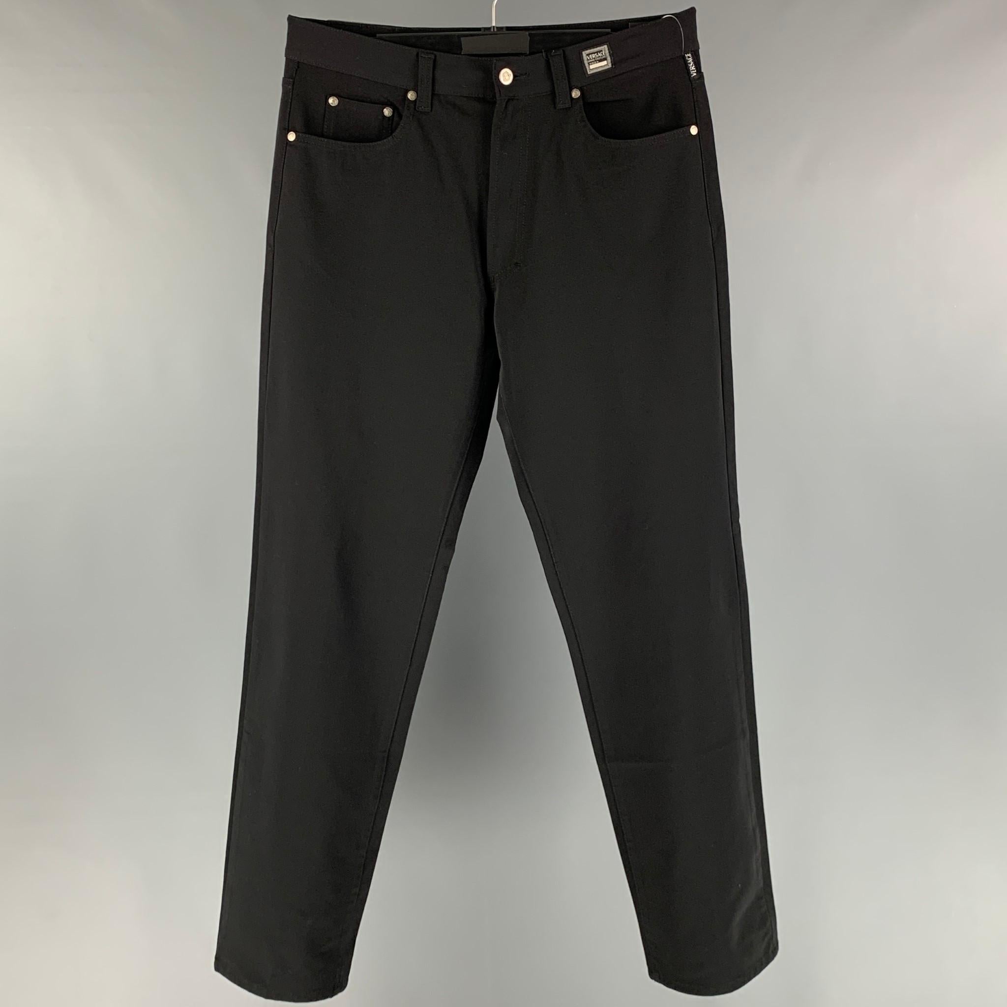 VERSACE JEANS COUTURE jeans pants comes in a black polyester blend featuring a stretch fit, medusa silver tone hardware, and a zip fly closure.

Excellent Pre- Owned Conditions.
Marked:50

Measurements:

Waist: 35 in.
Rise: 10 in.
Inseam: 32.5 in.  