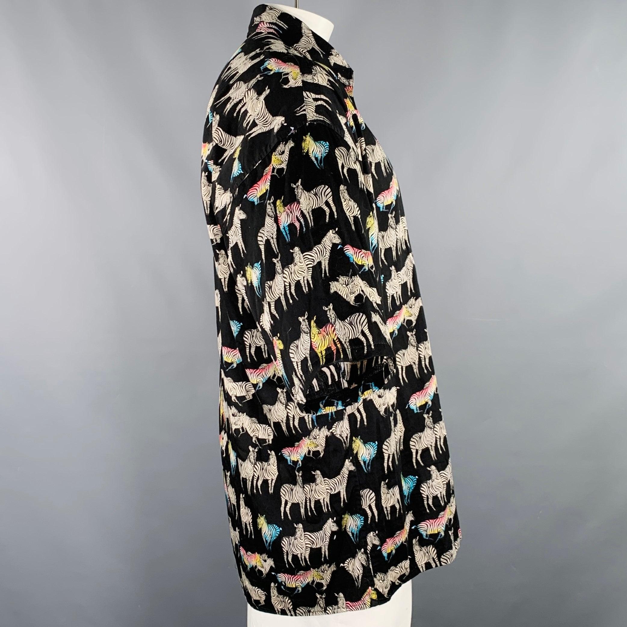 Vintage VERSACE JEANS COUTURE chemise à manches courtes
en coton noir tissé, avec un imprimé zébré noir, blanc et multicolore, une coupe oversize et une fermeture à boutons. Fabriqué en Italie. Excellent état. 

Marqué :   taille non marquée,