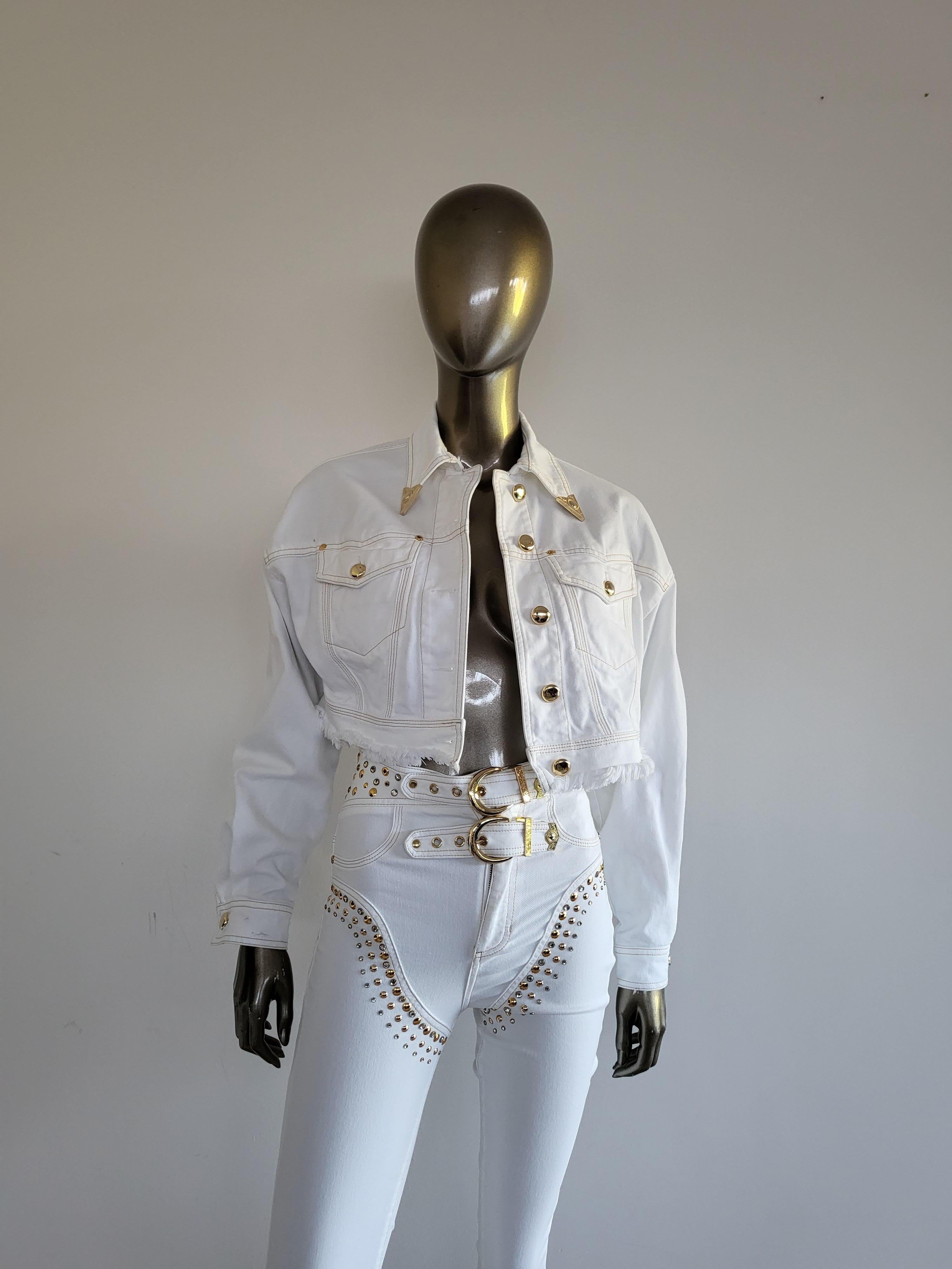 La cazadora vaquera recortada Versace Jeans Couture blanca con dobladillo desgastado es una obra maestra contemporánea que combina a la perfección vanguardia y alta costura. Confeccionada con una meticulosa atención al detalle, esta chaqueta
