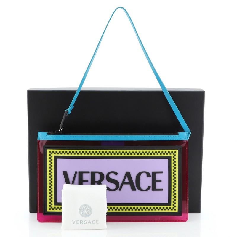 This Versace Logo Clutch PVC, crafted from pink PVC, features a top handle attached to zip fastening and black-tone hardware. Its zip closure opens to a pink PVC interior. 

Condition: Excellent. Light scuffs on exterior, scratches on
