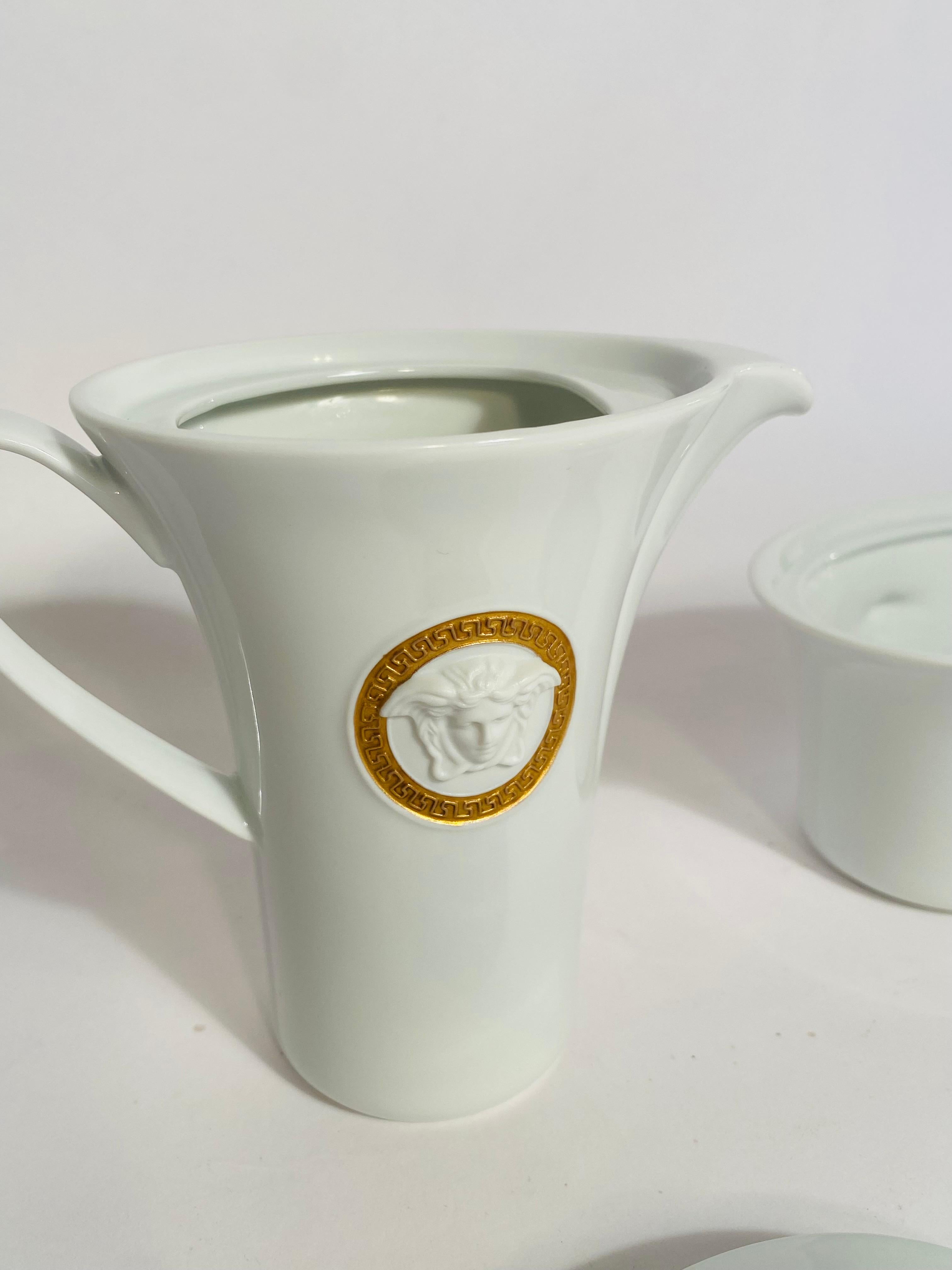 Versace Designed Crisp White Porcelain with raised Medusa Medallion Head in their collars. This pattern has Versace's signature design featuring the figurehead of Medusa. The Medallion Meandre D'or pattern is meticulously produced by Rosenthal of