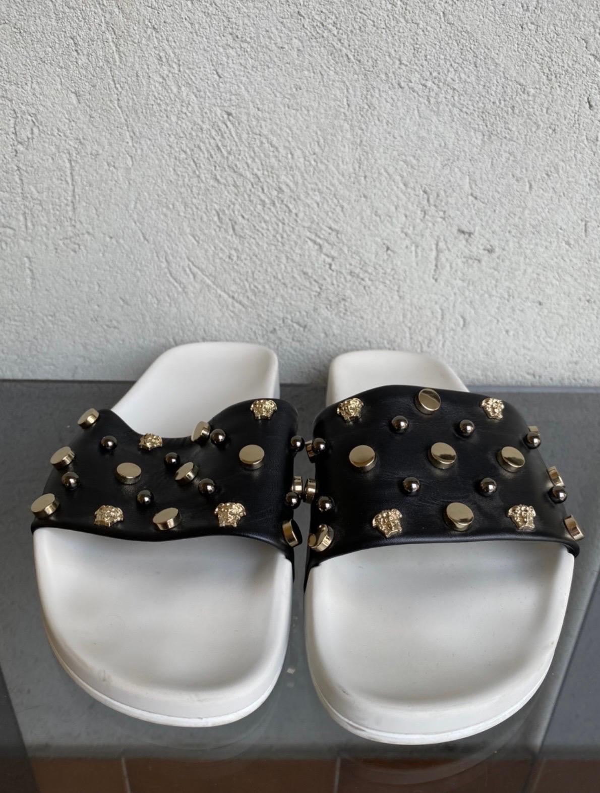 Versace slipper.
The insole is in white plastic, the part that wraps the foot is in black leather with studs and Medusa details , used but in good condition.