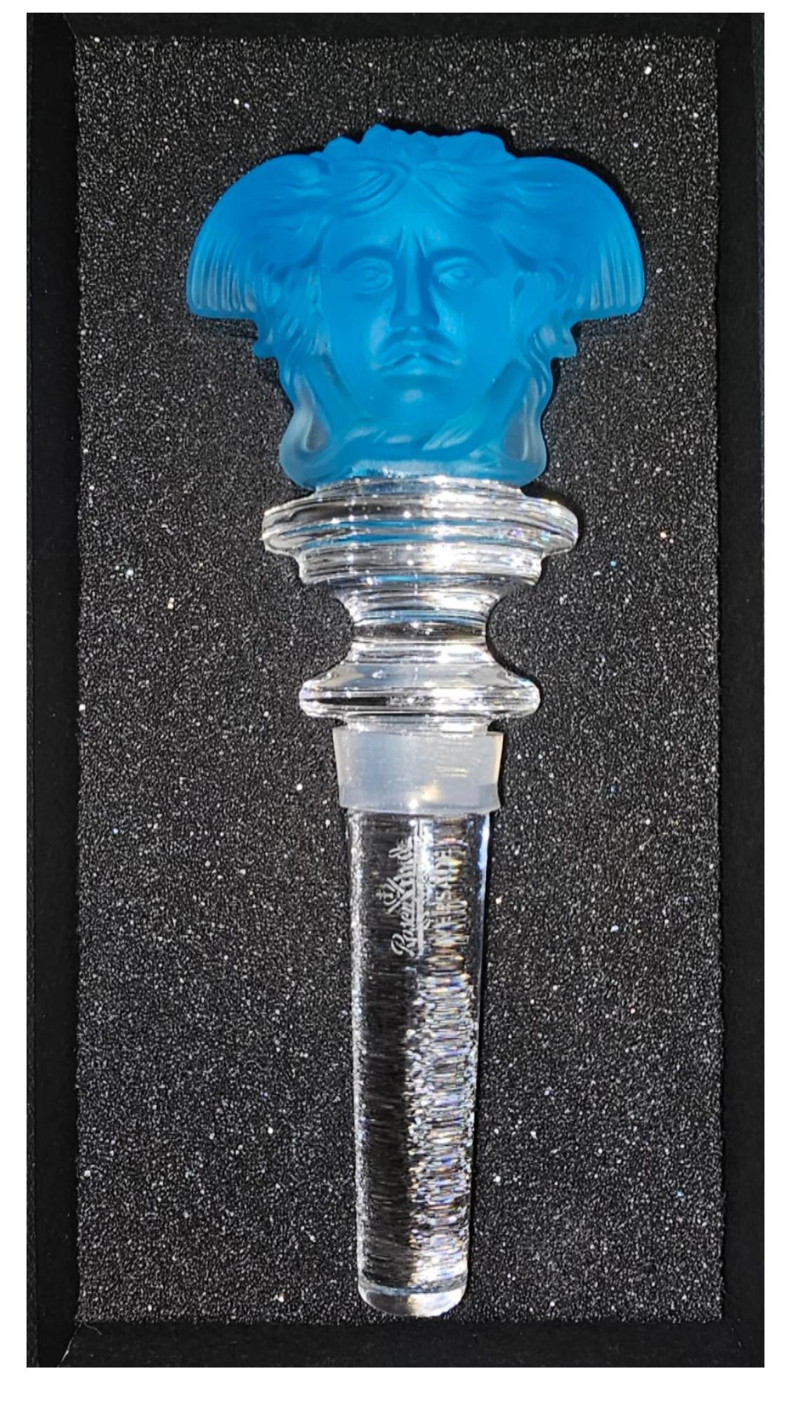 Elevate your barware with this stunning Versace 'Medusa' wine stopper, crafted from radiant blue crystal. Designed by Rosenthal for the prestigious Versace Home Collection, this exquisite piece features the iconic Medusa head on both sides, adding a