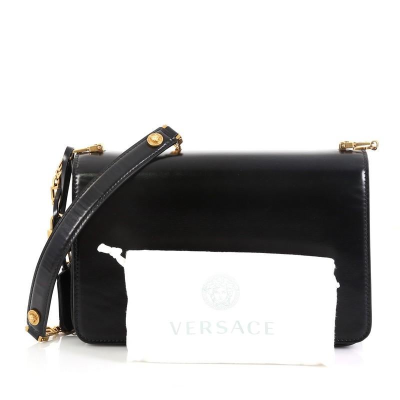 This Versace Medusa Padlock Icon Flap Bag Leather Medium, crafted in black leather, features a chain-link shoulder strap, iconic flap top with Medusa head medallions and gold-tone hardware. Its turn-lock closure opens to a black leather interior.