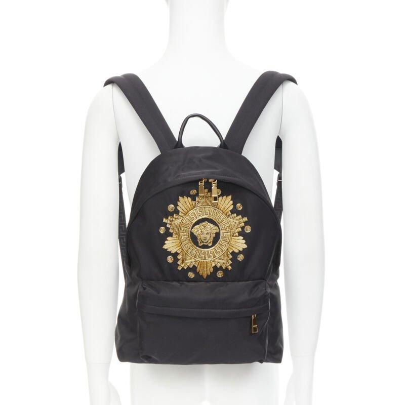 VERSACE Medusa Western Starburst embroidered black nylon backpack
Reference: TGAS/C00268
Brand: Versace
Designer: Donatella Versace
Model: DFZ5350 DRINY3 DNOOH
Material: Nylon
Color: Black, Gold
Pattern: Solid
Lining:  Fabric
Extra Details: Black