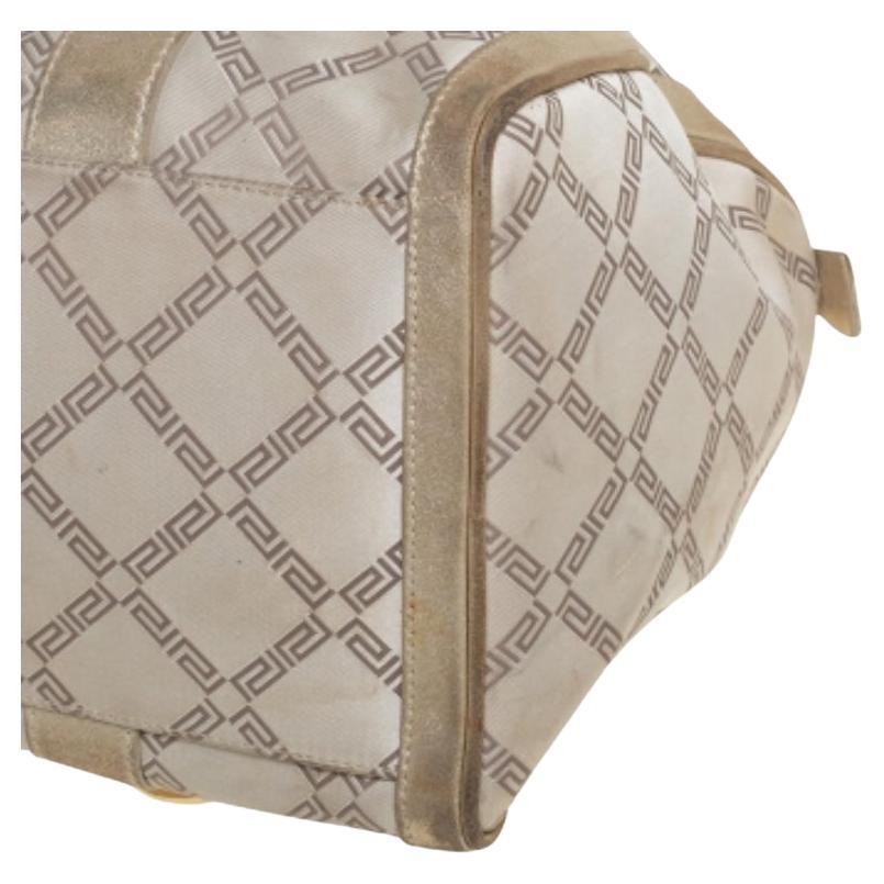 How gorgeous is this satchel from Versace! It carries an outstanding design and a fabulous interplay of leather & signature coated canvas. It is detailed with gold-tone hardware. It has a top leading to a satin interior while being held by two top