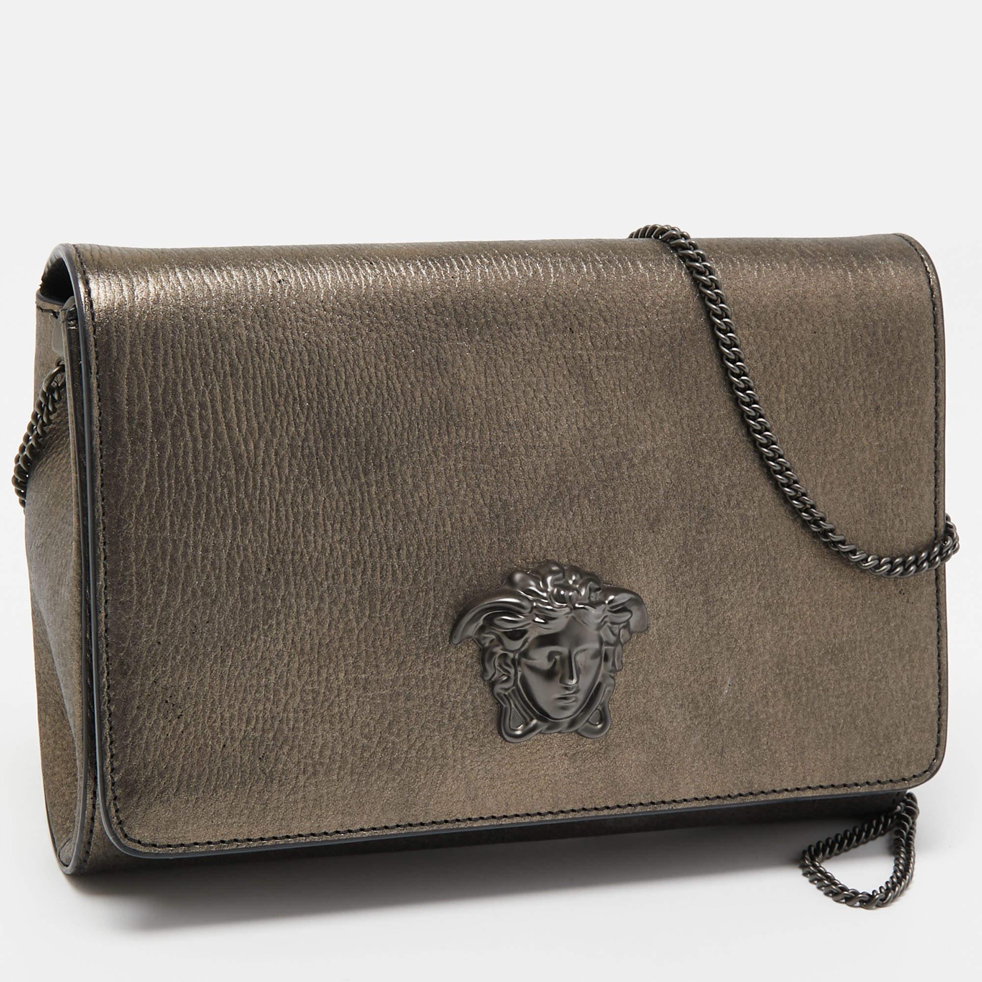 This clutch from Versace is designed in a metallic leather body. It brings a Medusa-adorned flap to secure the interior which is lined with satin. It comes held by a chain and is perfect for evenings.

