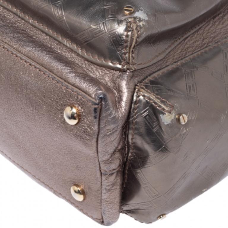 This creation from Versace will be a fantastic upgrade for your everyday shoulder bag. Crafted in Italy, it is made from metallic leather and features a big pocket at the front with the brand's accent on it. The bag has two side pockets, a chain and