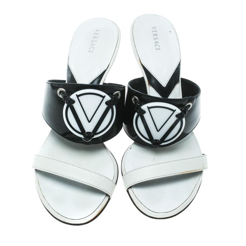 These monochrome Versace sandals are just lovely! They have been crafted from leather in an open toe silhouette and styled with a wide 'V' plaque detailed vamp strap. They come equipped with comfortable insoles and 8 cm stiletto heels. They'll look