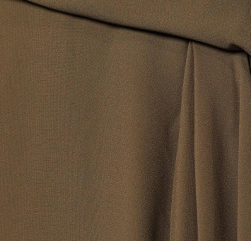 Look stylish and classy as you don this skirt from the House of Versace. It is fashioned in moss-green crepe fabric into a knee-length silhouette. It flaunts draped formations and comes with a zipper for fastening. Wear this Versace skirt with lacy