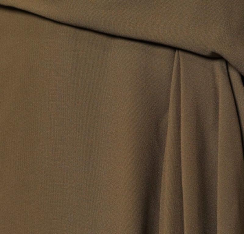 Look stylish and classy as you don this skirt from the House of Versace. It is fashioned in moss-green crepe fabric into a knee-length silhouette. It flaunts draped formations and comes with a zipper for fastening. Wear this Versace skirt with lacy