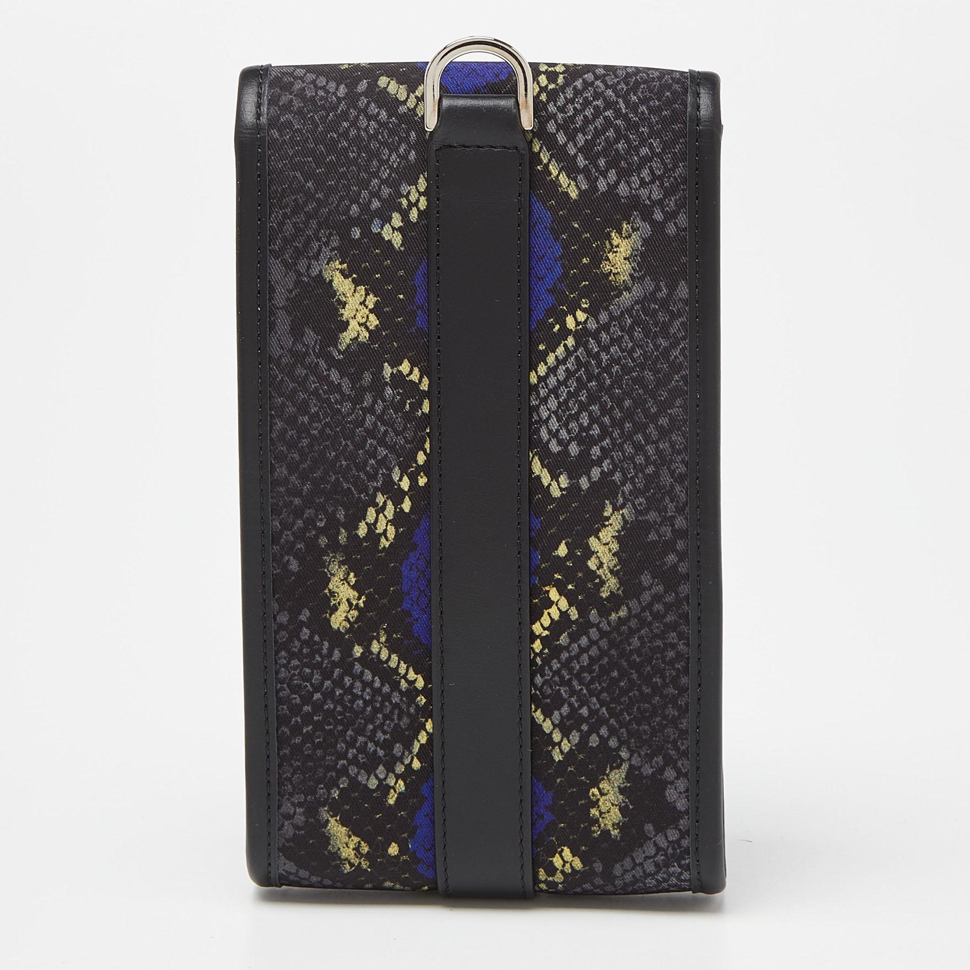 La pochette de l'étui de téléphone Versace vous permet d'élever votre équipement technologique. Confectionné en nylon et cuir luxueux, il respire l'opulence. Les motifs vibrants inspirés de la peau de serpent ajoutent une touche d'exotisme. Conçu à