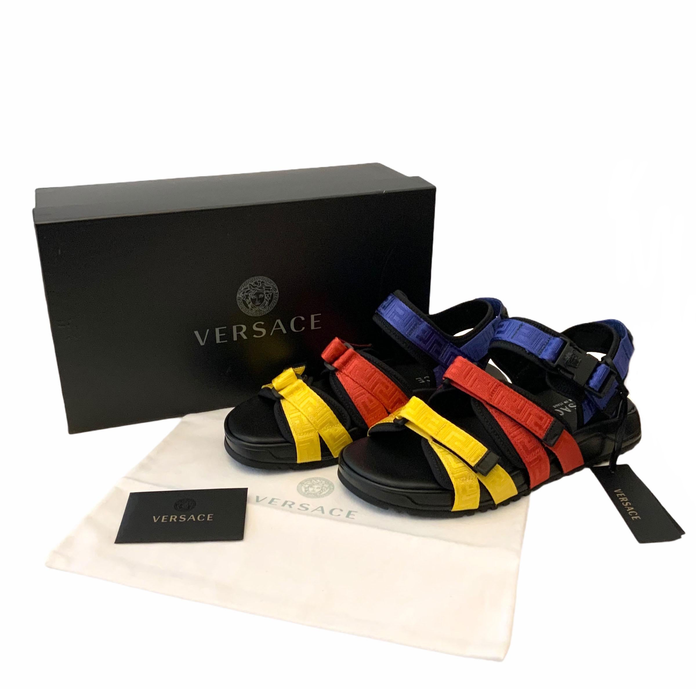 These pre-owned but new sandals from Versace are of a greek inspiration.
Each velcro strap is a colorblock in yellow, red and blue while the insole is crafted in black leather as a contrast.
They feature a black leather logo patch at the heel and a