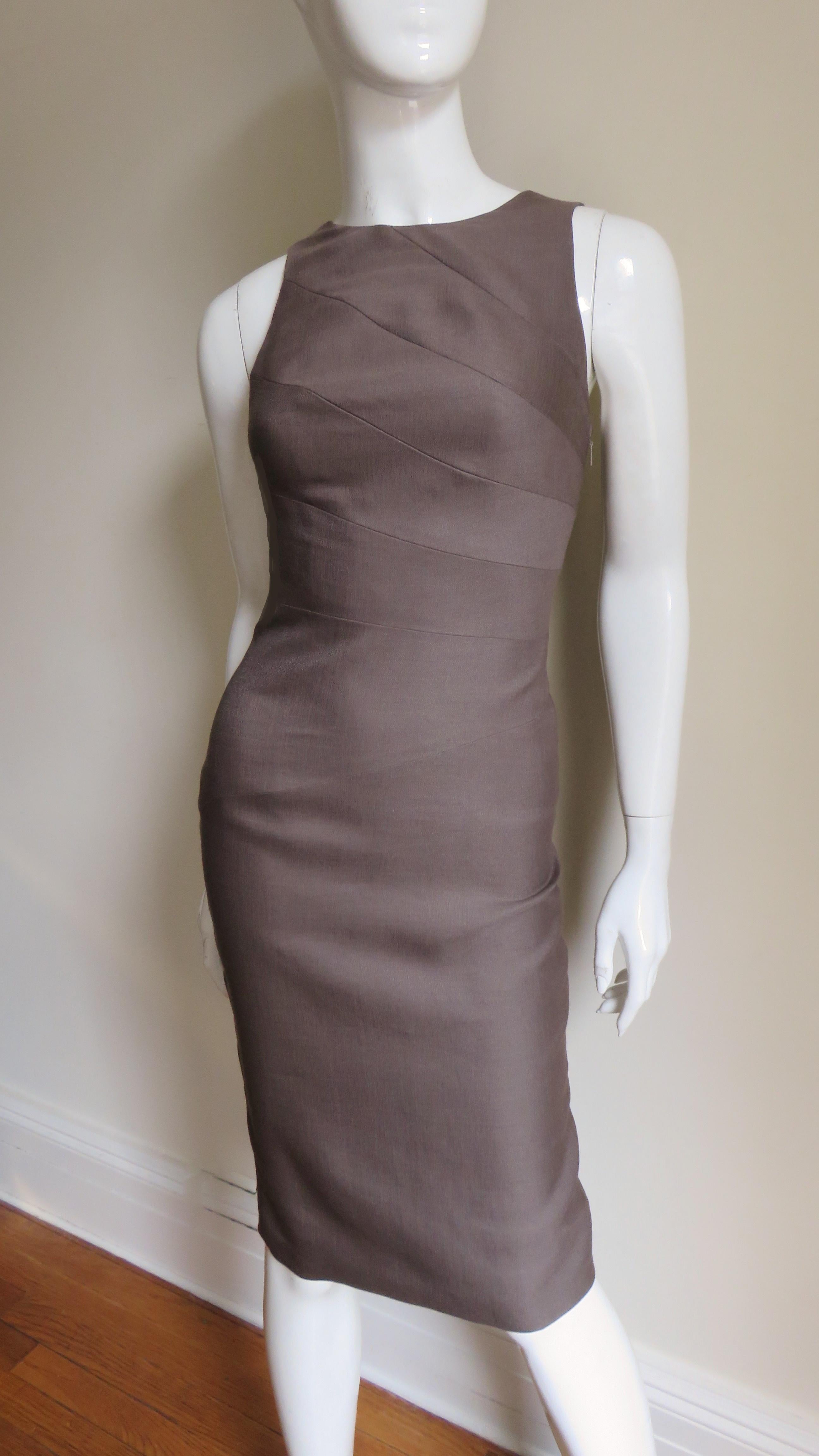 A body conscious brown silk blend dress from Versace.  It has a crew neckline front turning into shoulder straps in the back. The dress is fitted via seams wrapping at an angle around it's circumference though to the hem which has a back kick pleat.
