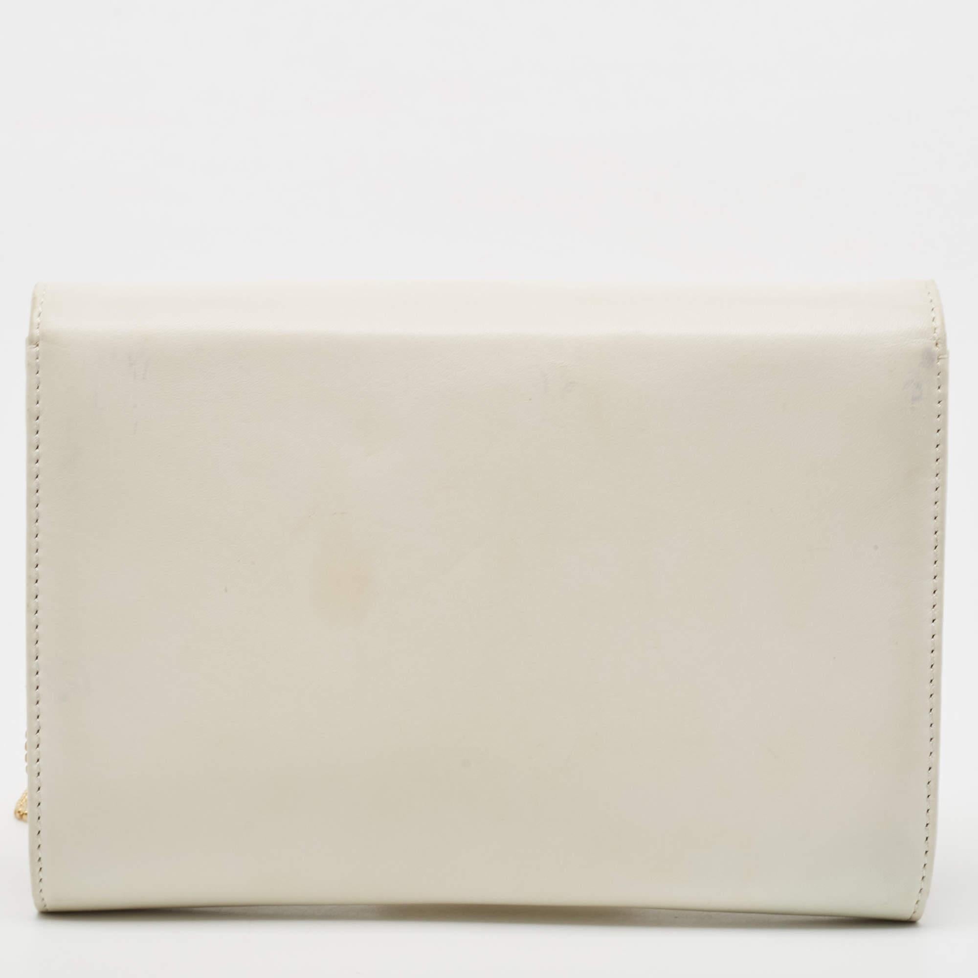 This clutch from Versace is designed in an off-white leather body. It brings a Medusa-adorned flap to secure the interior which is lined with satin. It comes held by a long chain and is perfect for evenings.

