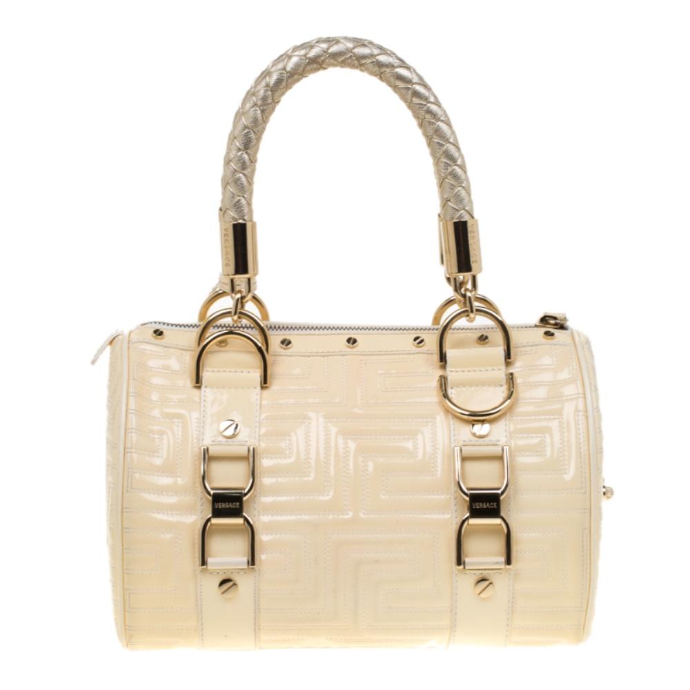 How gorgeous is this satchel from Versace! It carries a grand design and a fabulous interplay of leather and gold-tone hardware. It has a top leading to a fabric interior while being held by two woven handles. The quilts and the brand logo on the