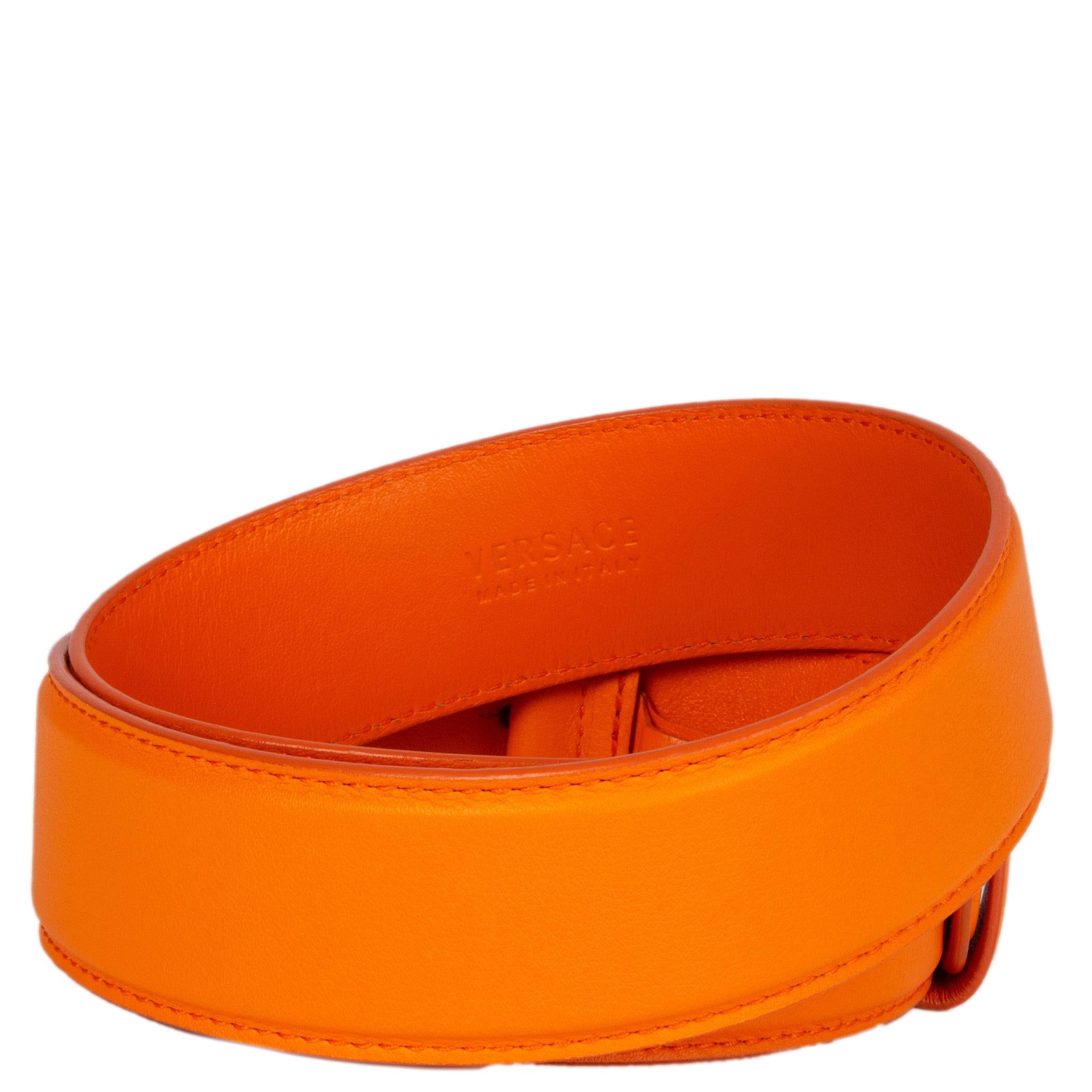 Versace belt in orange calfskin with a round gold- and silver-tone medusa metal buckle. Has been worn and is in excellent condition. 

Tag Size 75
Width 4cm (1.6in)
Fits 70cm (27.3in) to 80cm (31.2in)
Length 89cm (34.7in)
Buckle Size Height 5cm