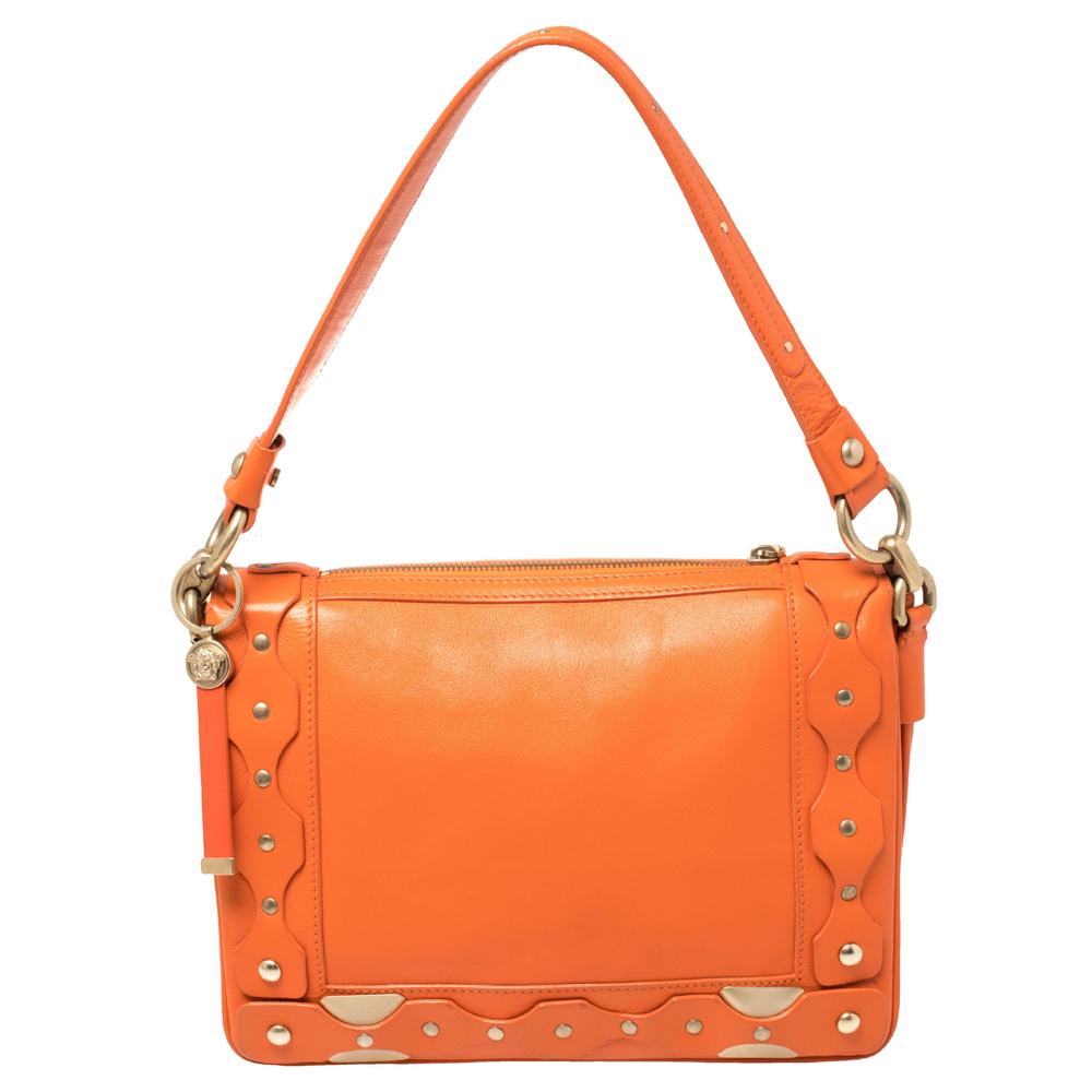 This orange shoulder bag from Versace has been designed to be a worthy style companion! Crafted from leather, the bag features a flap closure and gold-tone accents. It is equipped with a single handle and a satin-lined interior for you to carry your