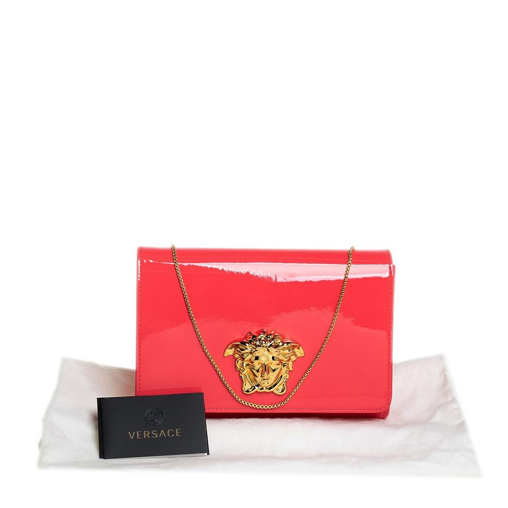 This clutch from Versace is designed in a peach patent leather body. It brings a Medusa-adorned flap to secure the interior which is lined with fabric. It comes held by a gold-tone chain and is perfect for evenings.

Includes: Info Booklet, Original