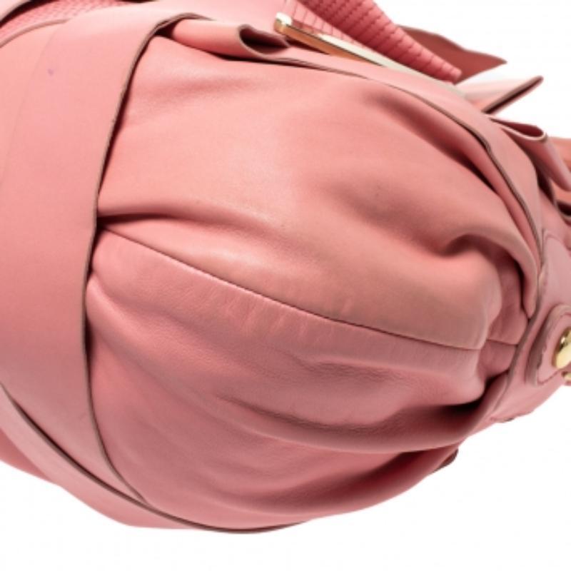 Puoi sicuramente contare su questa deliziosa borsa con fiocco di Versace per un look degno di nota. La borsa è realizzata in pelle rosa ed è impreziosita da finiture dorate. Questa elegante bellezza è caratterizzata da doppi manici, un dettaglio a