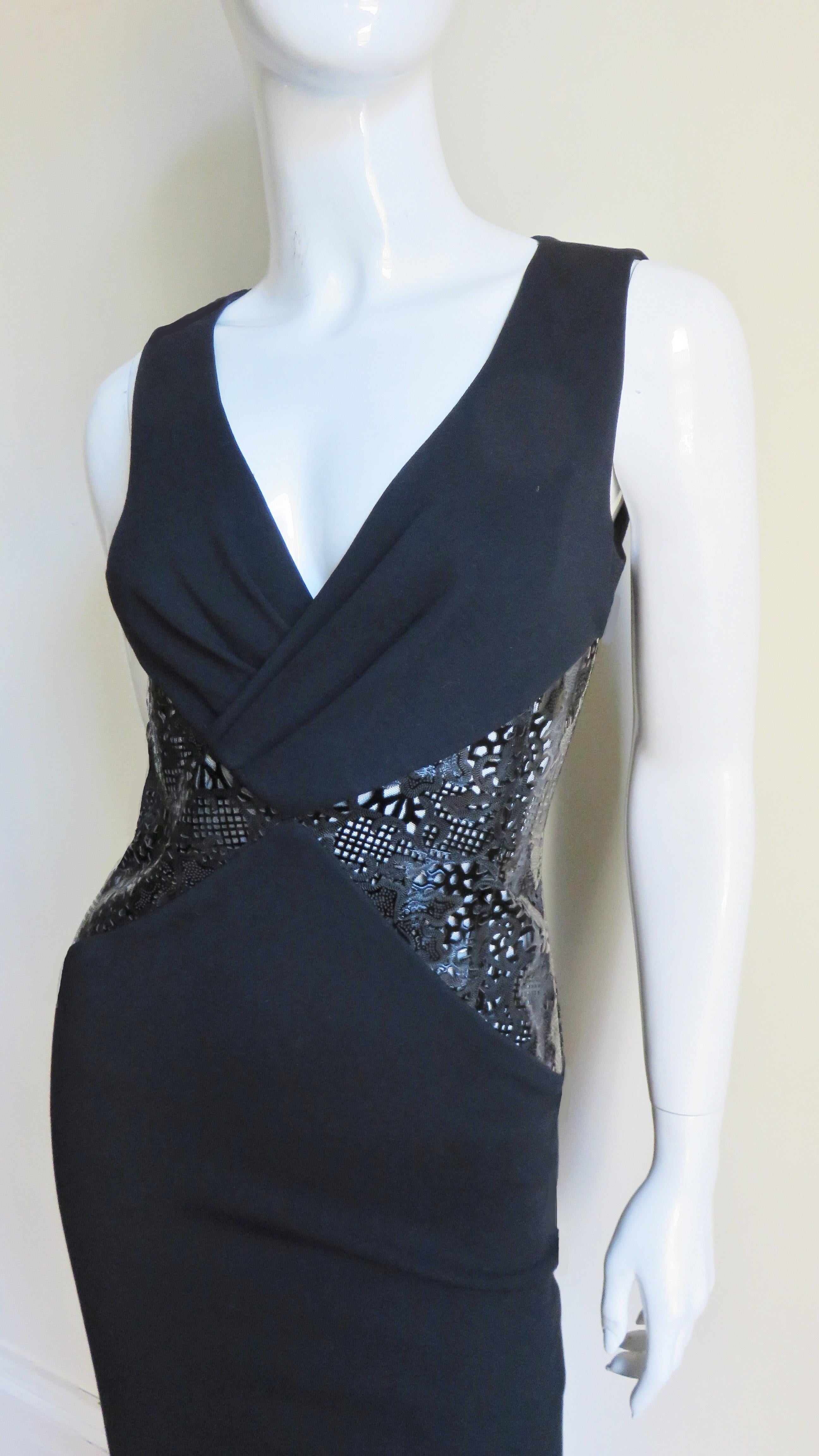 A stunning black jersey dress from Versace. It is sleeveless, fitted with a V front neckline and 2 triangular insets at the front and back waist of intricately laser cut black patent leather in a series of perforations in varying sizes and shapes.