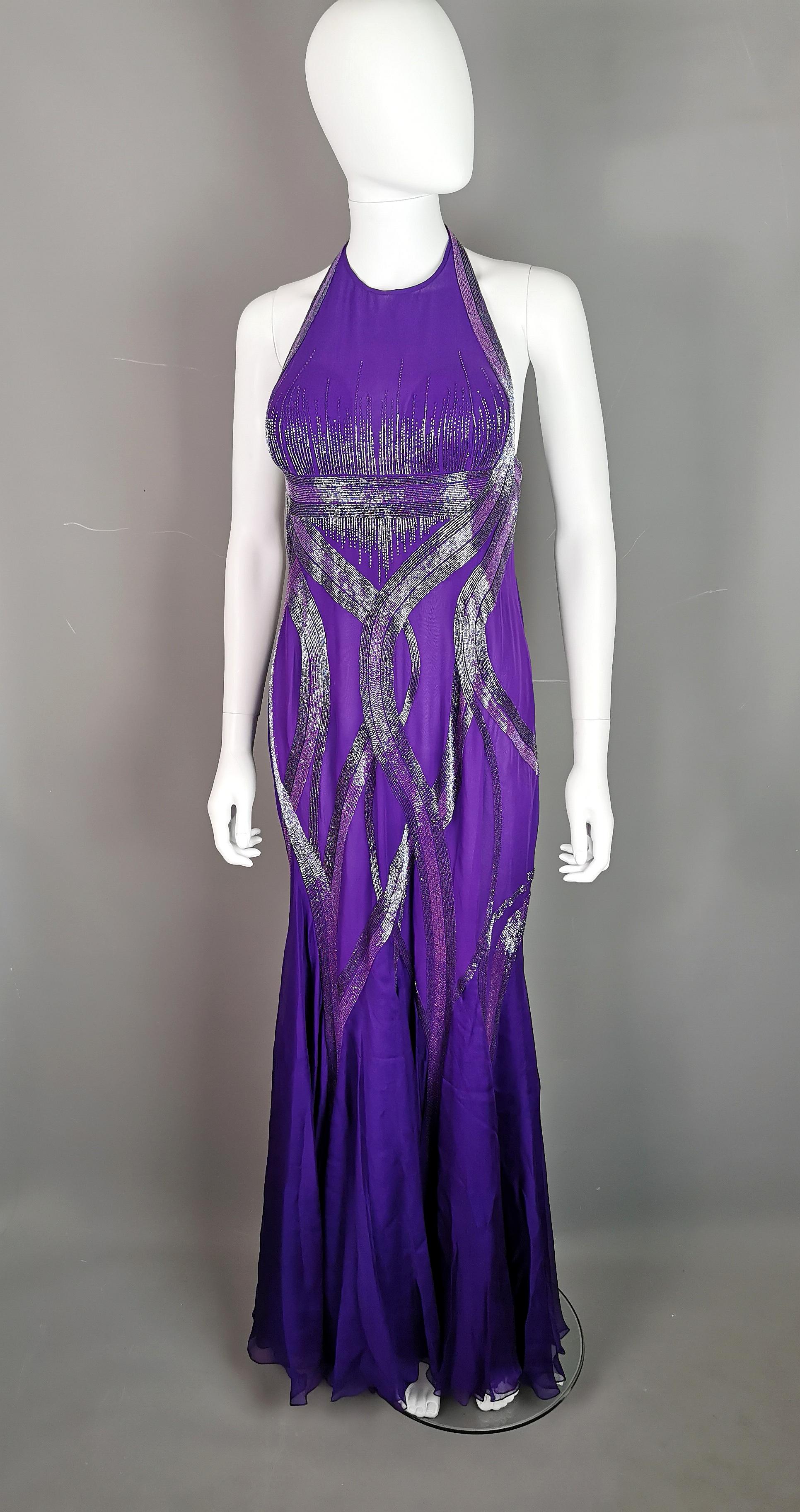 Magnifique robe de soirée vintage Versace en mousseline de soie violette perlée.

La silhouette épouse la forme du corps et les jupes en cascade s'épanouissent dans la moitié inférieure, avec une légère traîne dans le dos qui confère un peu