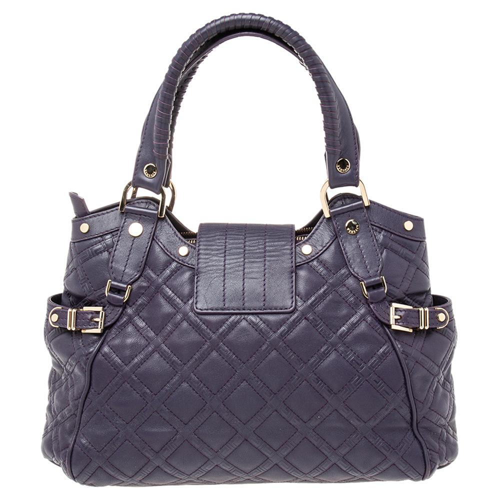 Look your fashionable best when you step out swinging this fabulous satchel from Versace. It is crafted from purple quilted leather and exudes the label’s incredible craftsmanship. It flaunts dual handles, a Medusa plaque on the front, and a