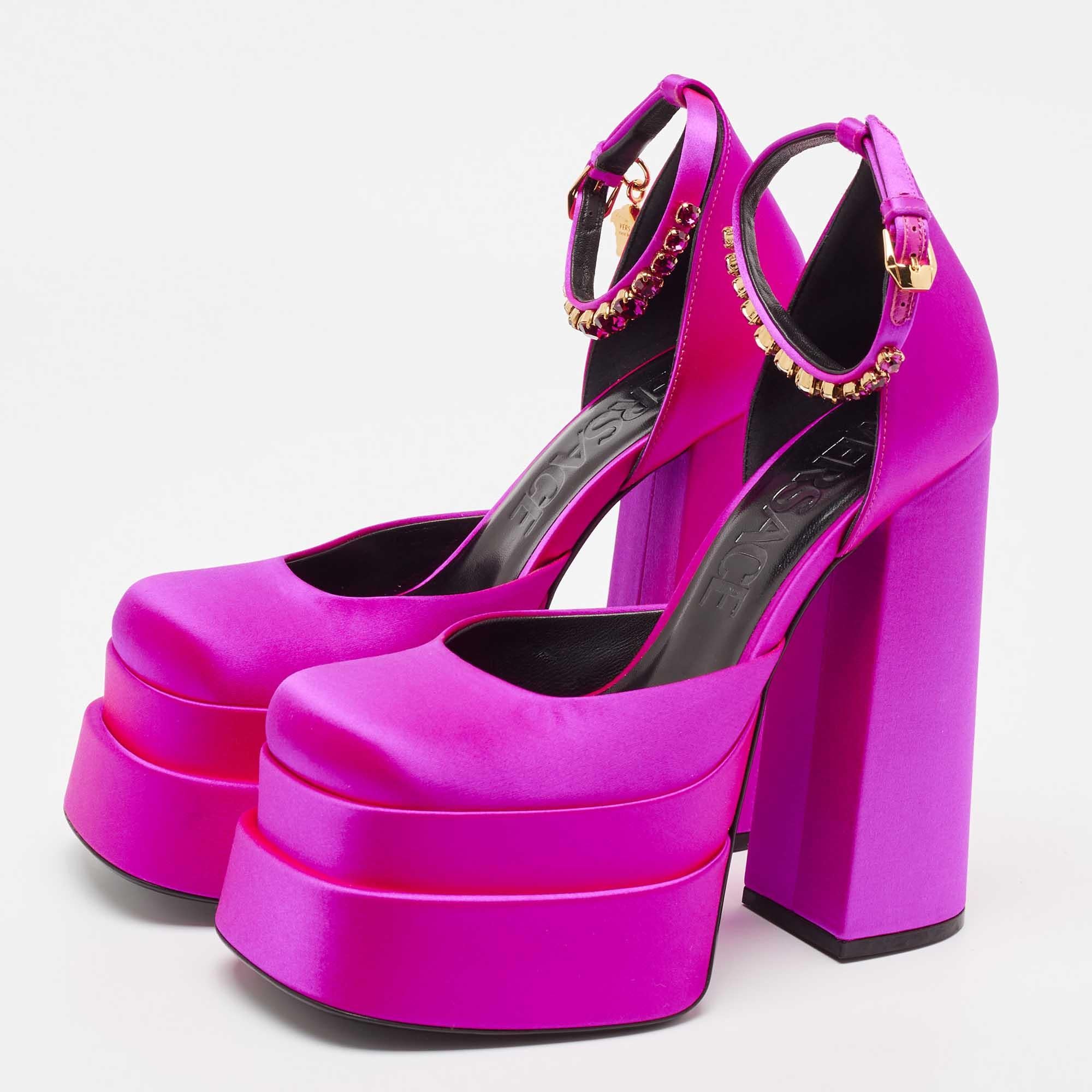 The Versace pumps are a luxurious and glamorous footwear choice. These pumps feature a classy purple satin material adorned with sparkling crystal embellishments on the ankle strap and boast a comfortable block heel with a supportive ankle strap