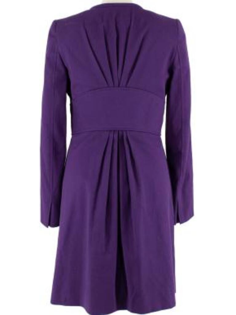 Versace Purple Silk Blend Coat with Gold Belt Detail 
 

 - Rich purple cotton and silk blend textured woven coat 
 - Collarless longline silhouette 
 - Built in belt detail with golden front clasp
 - Hidden buttons down the front 
 - Shoulder pads