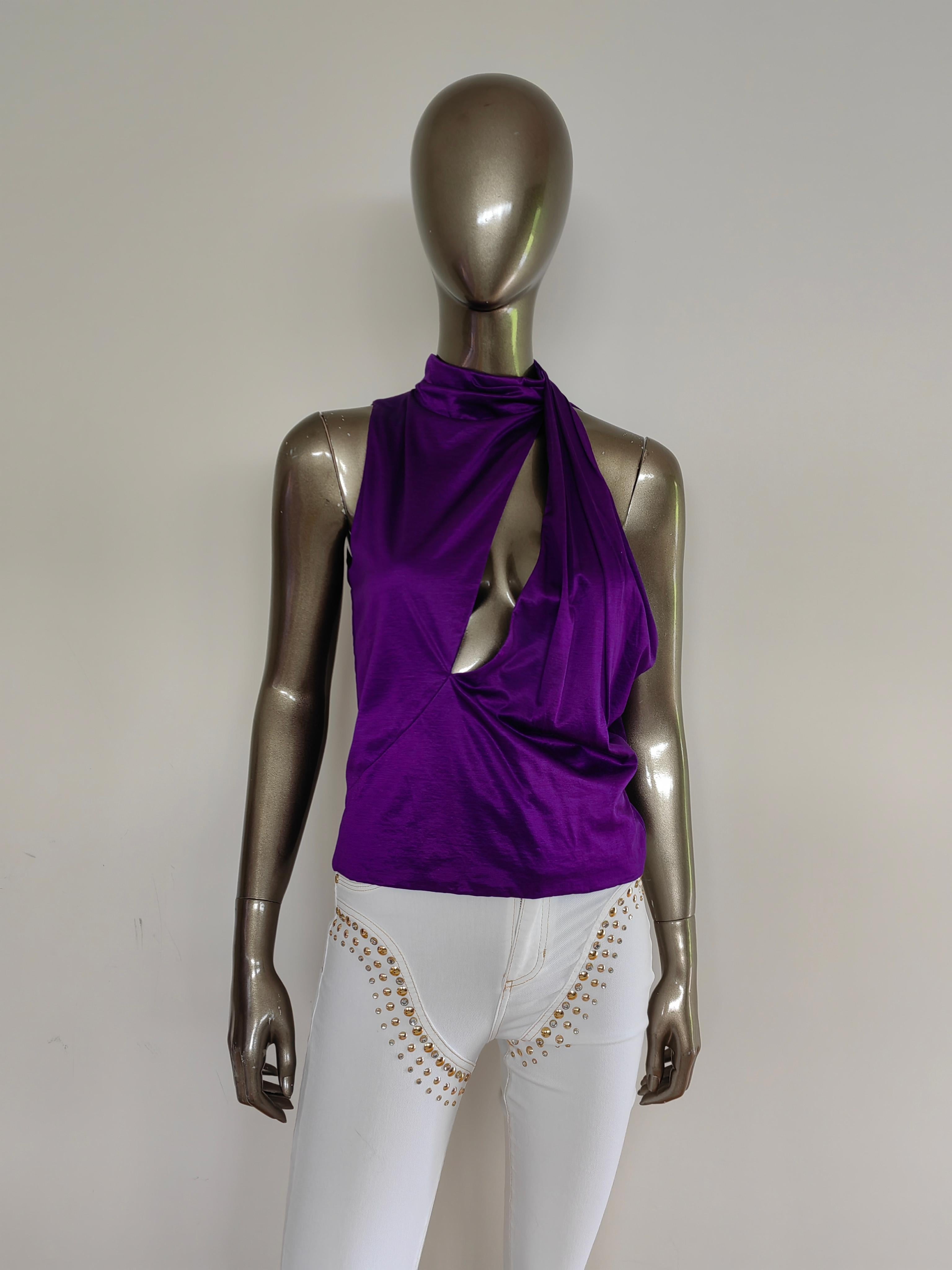 The Versace Purple Slashed Halter Top is a striking piece that combines contemporary design with luxurious craftsmanship. Crafted from high-quality viscose fabric, this top features a high neck and a distinctive front cut-out, adding a modern twist