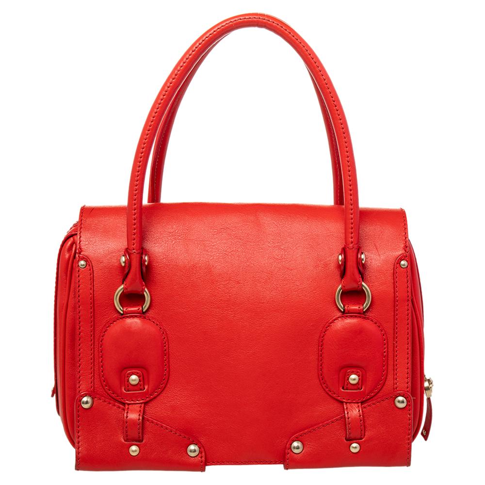 This stylish and striking tote bag hails from the house of Versace. It has been crafted from quality leather in Italy and is presented in a lovely shade of red. It has a front flap, a logo-adorned turn-lock, dual handles, stud detailing and