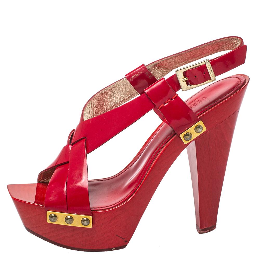 Versace yet again brings a stunning set of sandals that makes us marvel at its beauty and craftsmanship. Crafted from glossy patent leather in a red shade, they are adorned with open toes and block heels supported by platforms. There are endless