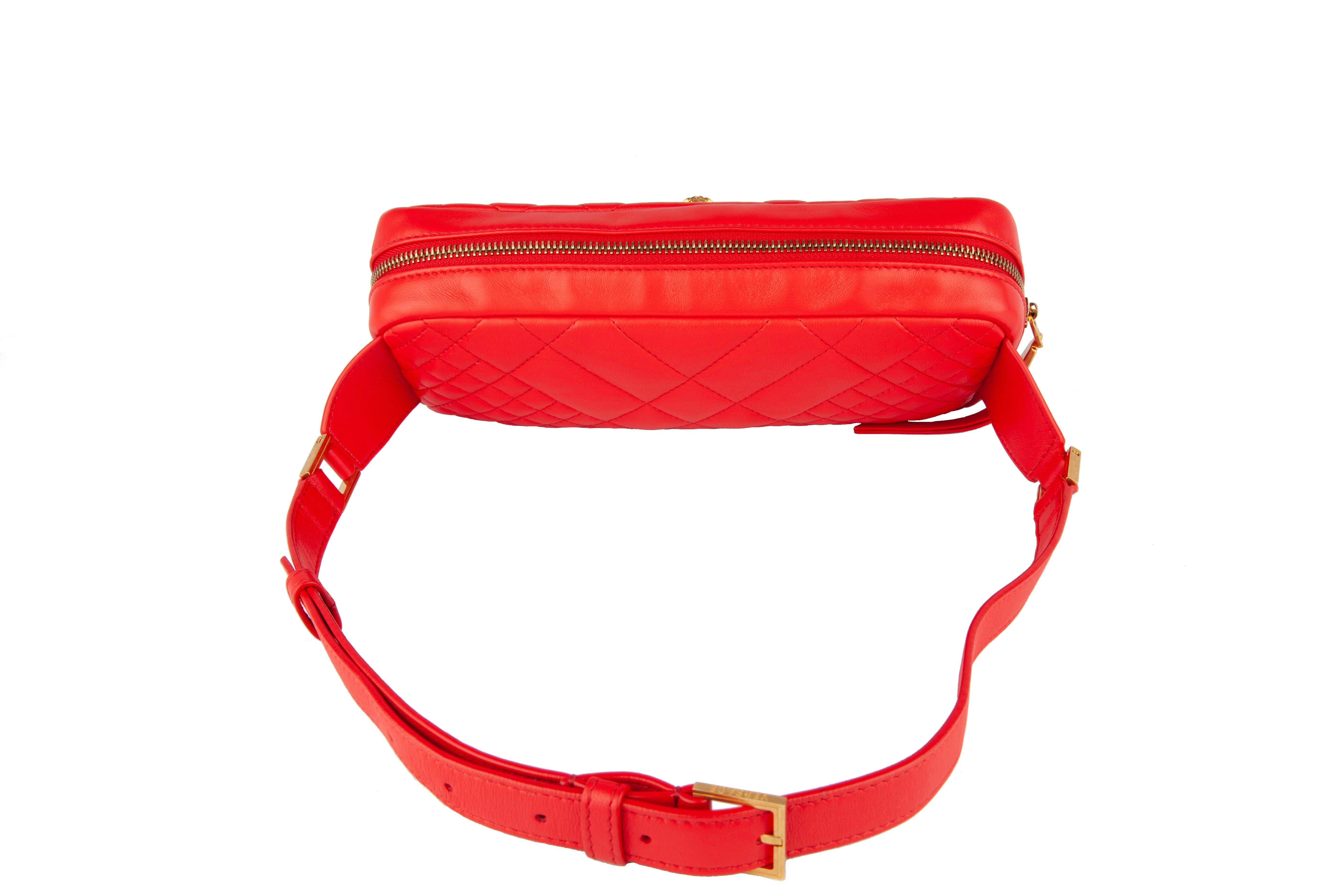 This red Versace Quilted Icon Belt Bag features signature gold medusa hardware, quilted calf leather, top zip closure, and an adjustable belt strap. Brand new. Made in Italy.

Approx. Dimensions: 11