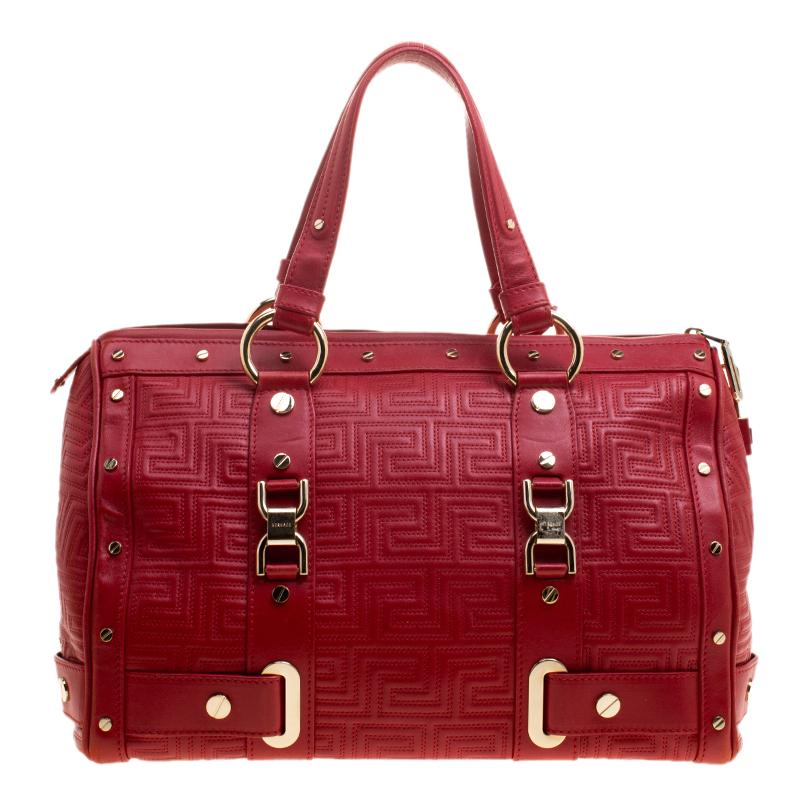 How gorgeous is this satchel from Versace! It carries an outstanding design and a fabulous interplay of red leather and gold-tone hardware. It has a top zipper leading to a satin interior while being held by two handles. The quilt detailing and the