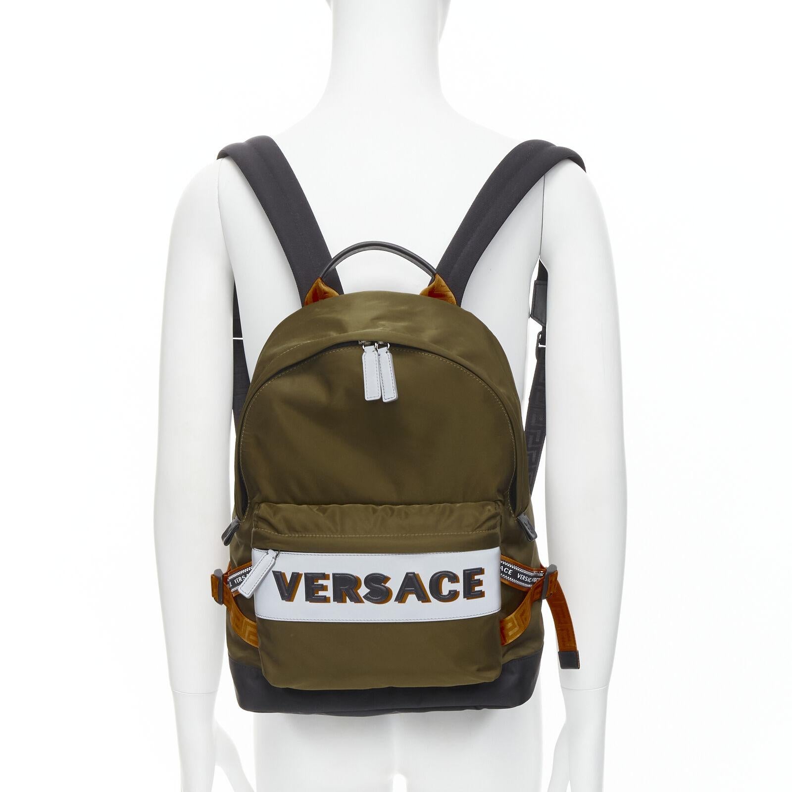 VERSACE Reflective Logo green nylon orange Greca strap backpack
Reference: TGAS/C00873
Brand: Versace
Designer: Donatella Versace
Model: DFZ8069 DNY2R K048E
Material: Nylon
Color: Green, Orange
Pattern: Solid
Closure: Zip
Lining:  Nylon
Extra