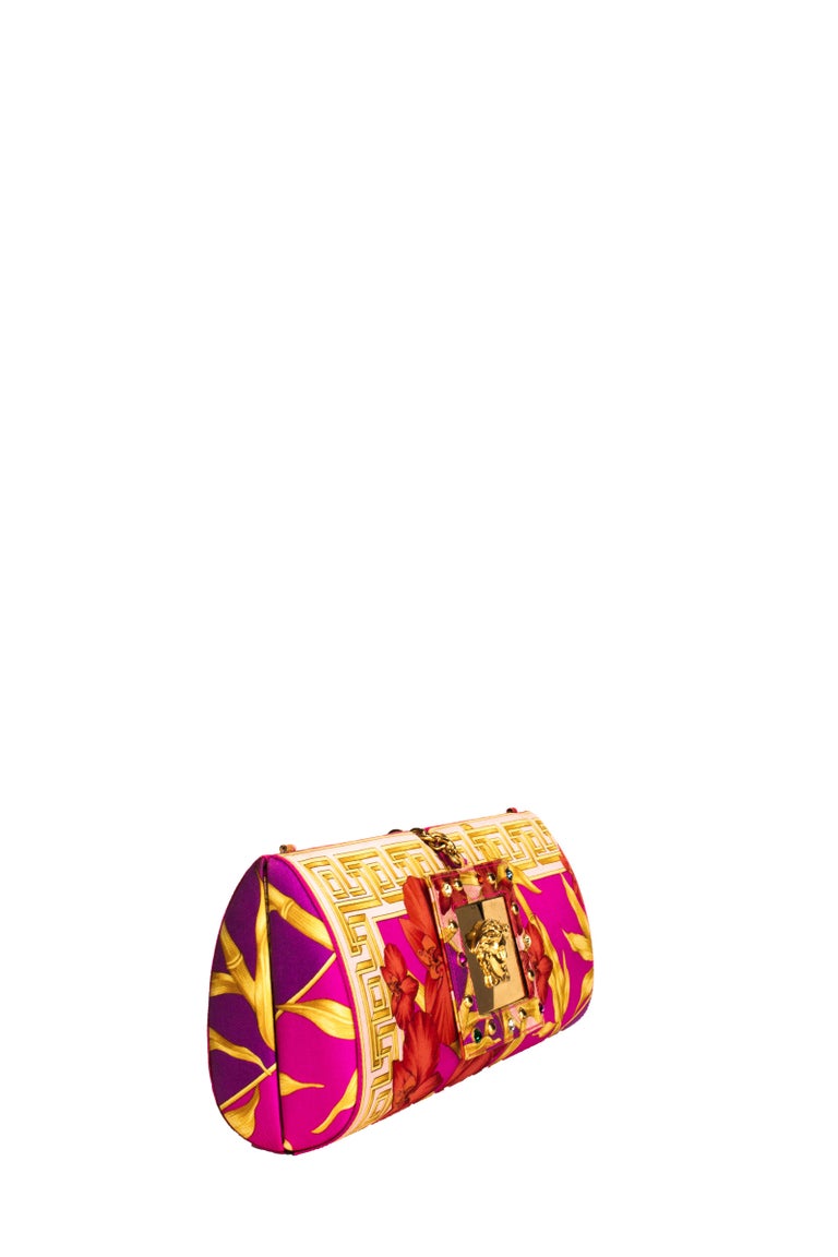 The RealList presents: This stunning, convertible Versace clutch is constructed in a silk pink jungle print. Front and center, a mirrored gold medusa plaque accents the snap closure. Donatella designed this convertible clutch for the Gianni Versace