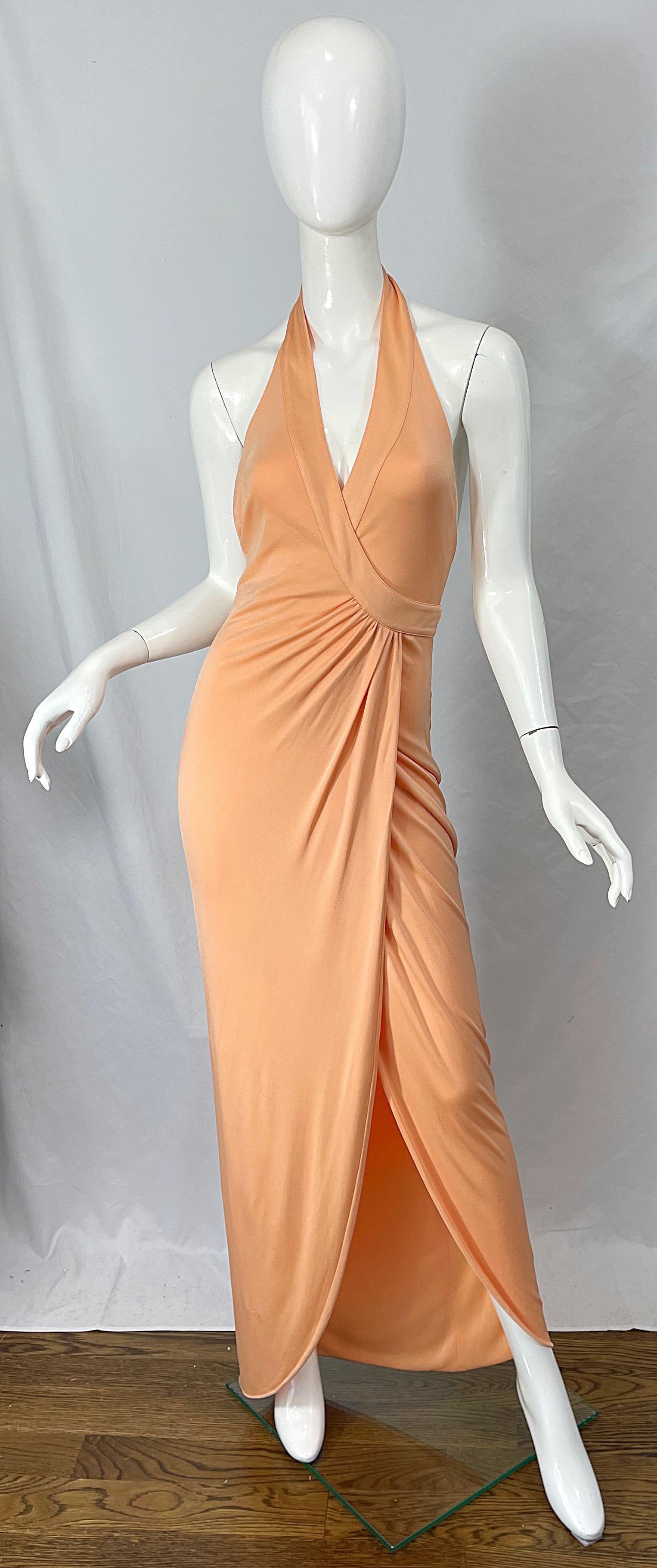 Sexy GIANNI VERSACE Spring / Summer 2005 peach / salmon silk jersey runway halter gown! Unique flattering wrap style. Gold metal Medusa medallion at center back detaches with hidden snaps for waist straps to wrap around. Slit reveals just the right