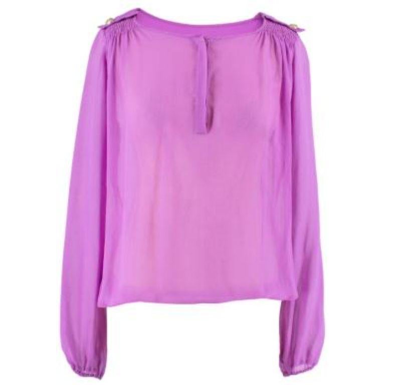 Versace Purple Silk Blouse

- Round neck
- Concealed embossed buttons
- Gold-tone Medusa head embossed buttons to each shoulder
- Puff sleeves with elasticated cuffs
- Elasticated hemline

Please note, these items are pre-owned and may show some