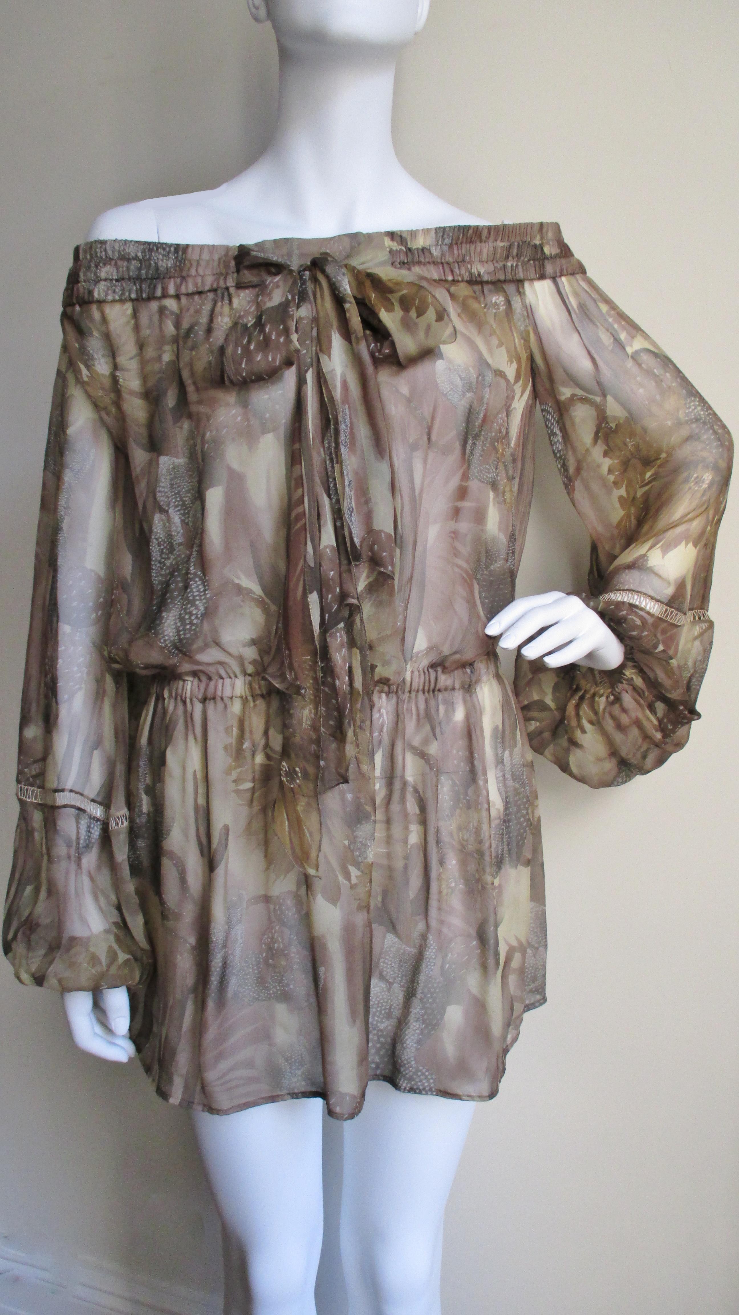 A great silk cactus print dress in beige and browns from Versace. The dress is worn off the shoulders with a flexible band and a center front tie.  It is a blouson style with an adjustable drop waist resting at the upper hips. There is elaborate
