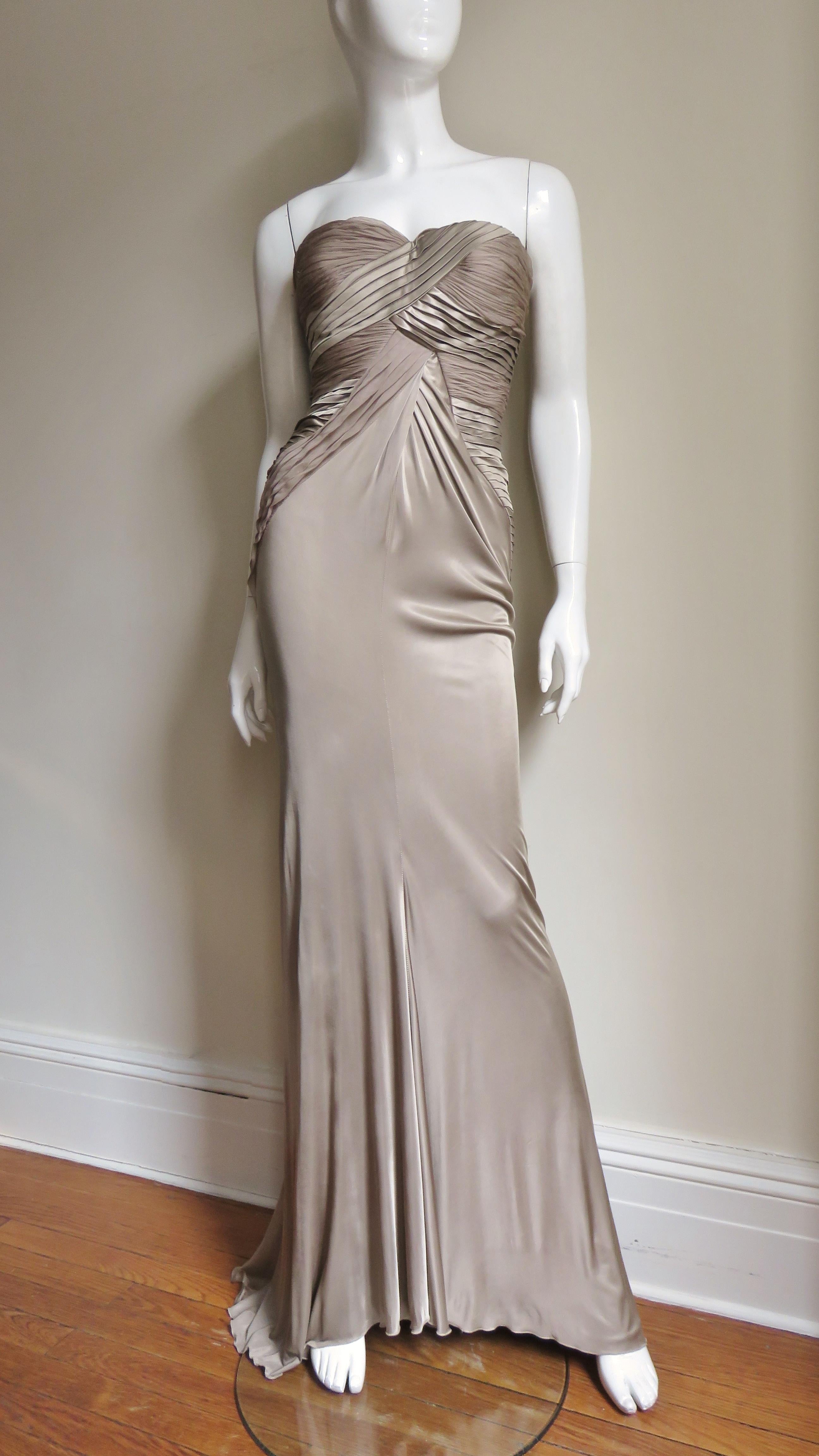 A beautiful light taupe fine knit silk gown from Versace.  It is strapless with molded cups, a boned bodice and panels of finely pleated silk crossing the bust in the front, along the sides and in a thatched pattern at the back to just below the
