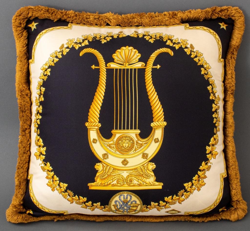 Coussin en soie Versace, de forme carrée, représentant une lyre dorée sur chaque face, et portant le cachet 