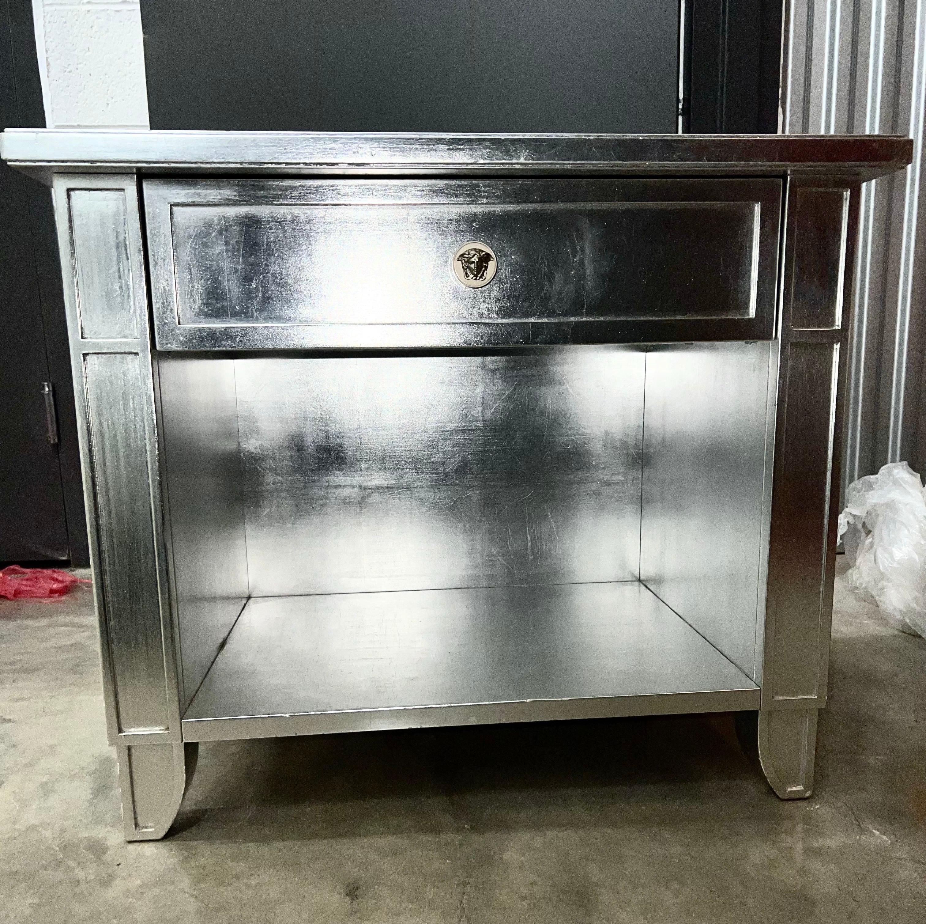 Versace silvered end tables with drawer, Medusa handle, Gianni Versace, c. 1995. Silver leaf covers entire piece. This listing is for the pair. Can be used as side / end tables and/or nightstands. Versace Medusa pulls. Made in Italy. All original.