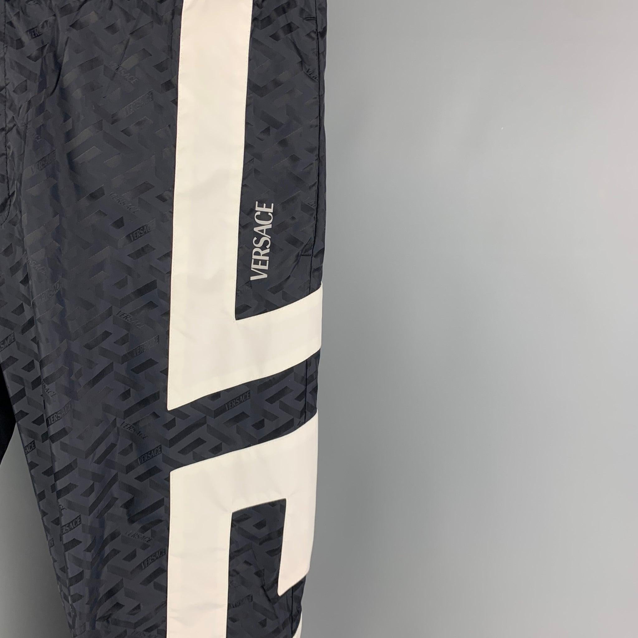 VERSACE pants comes in a navy geometric print polyamide with a white trim detail featuring elastic cuffs, elastic waistband, and a zip fly closure.
Excellent
Pre-Owned Condition. 

Marked:   54 

Measurements: 
  Waist: 34 inches Rise: 12 inches